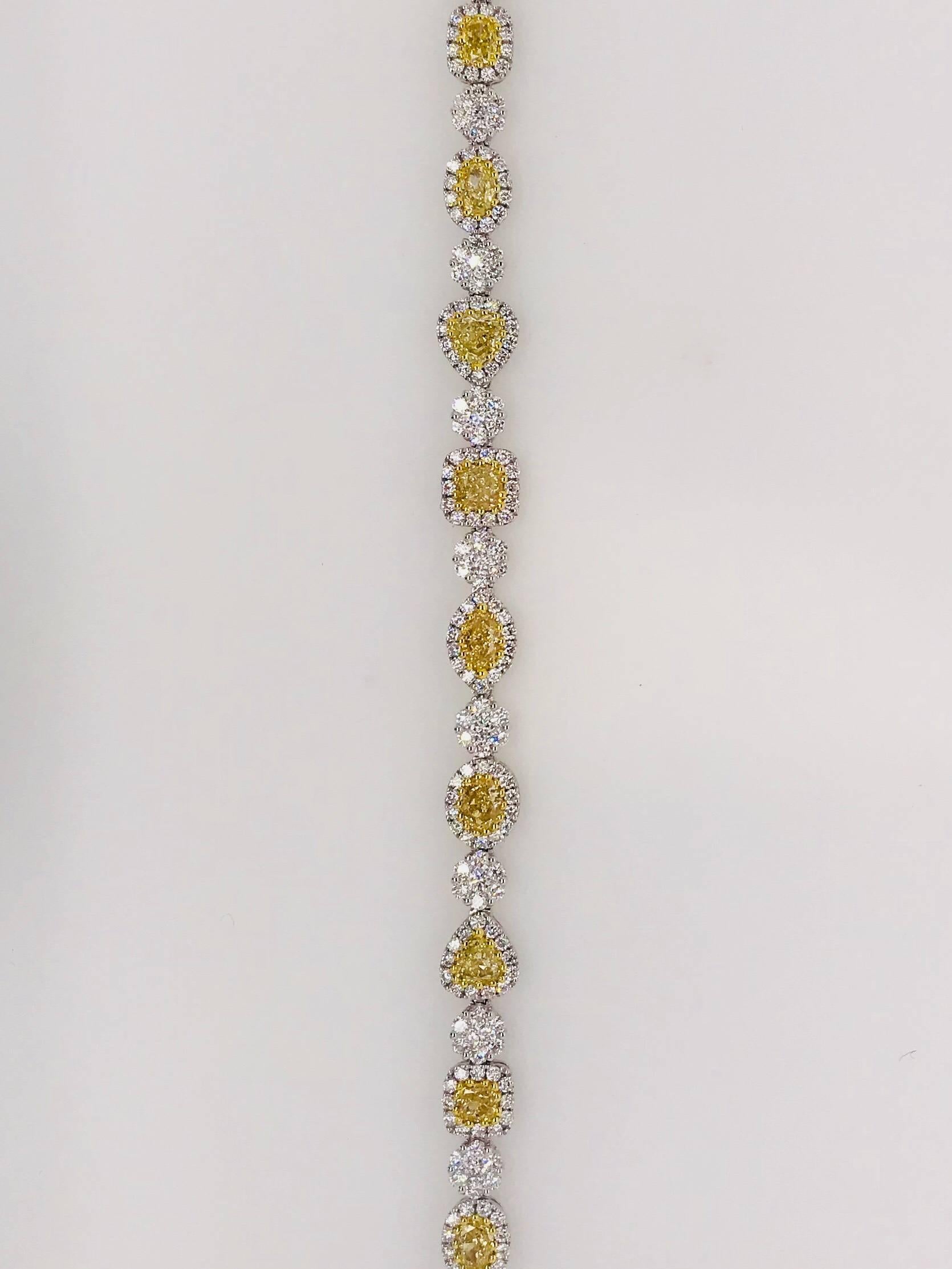 This stunning Matthew Ely bracelet is 18 ct White gold and set with 14 = 4.09CT fancy yellow colour diamonds + 276 = 3.59CT round brilliant cut diamonds. Each featured diamond is encased in a diamond halo.
