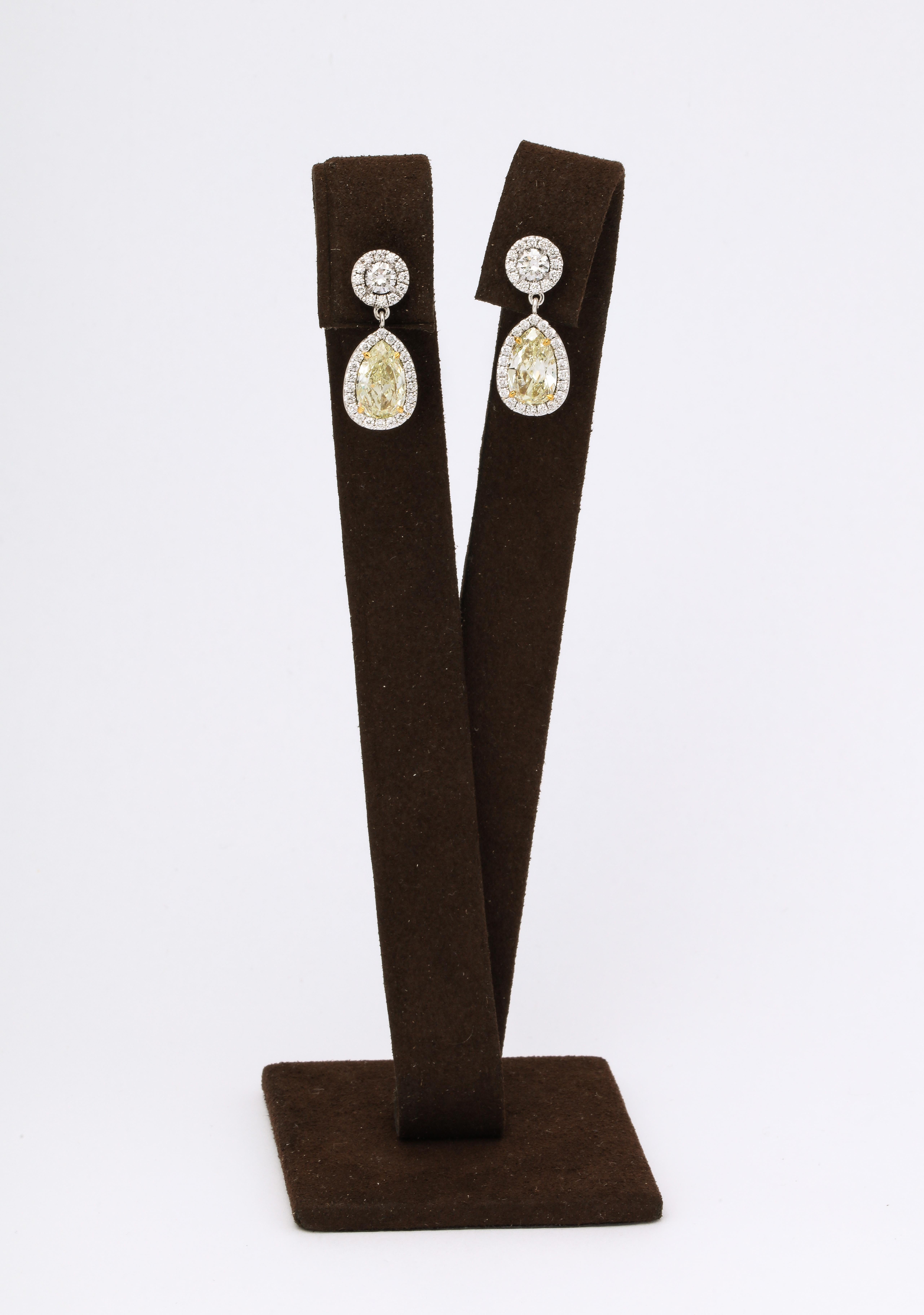 
Over 3 carats of pear shaped yellow diamonds suspended from round diamond studs. All surrounded by colorless white smaller round brilliant cut white diamonds. 

1.33 carats of white diamonds. 

set in 18k white and yellow gold. 

Just under an inch