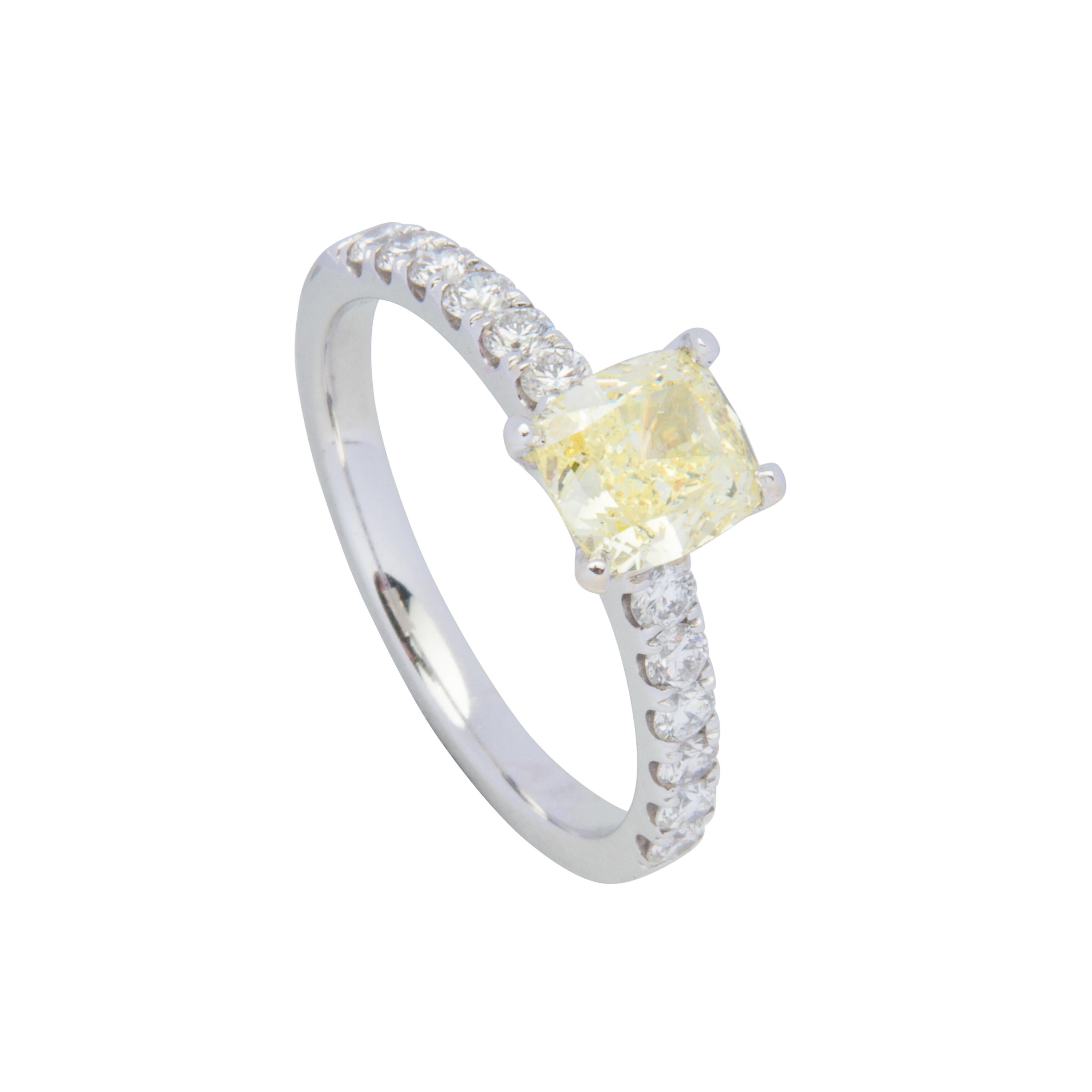 18 karat white gold engagement ring featuring 1 GIA certified cushion cut Fancy Yellow Diamond 1.02ct SI1, also set with 12 round brilliant cut diamonds totalling 0.18ct.  Size US6, sizeable +2 or -2.