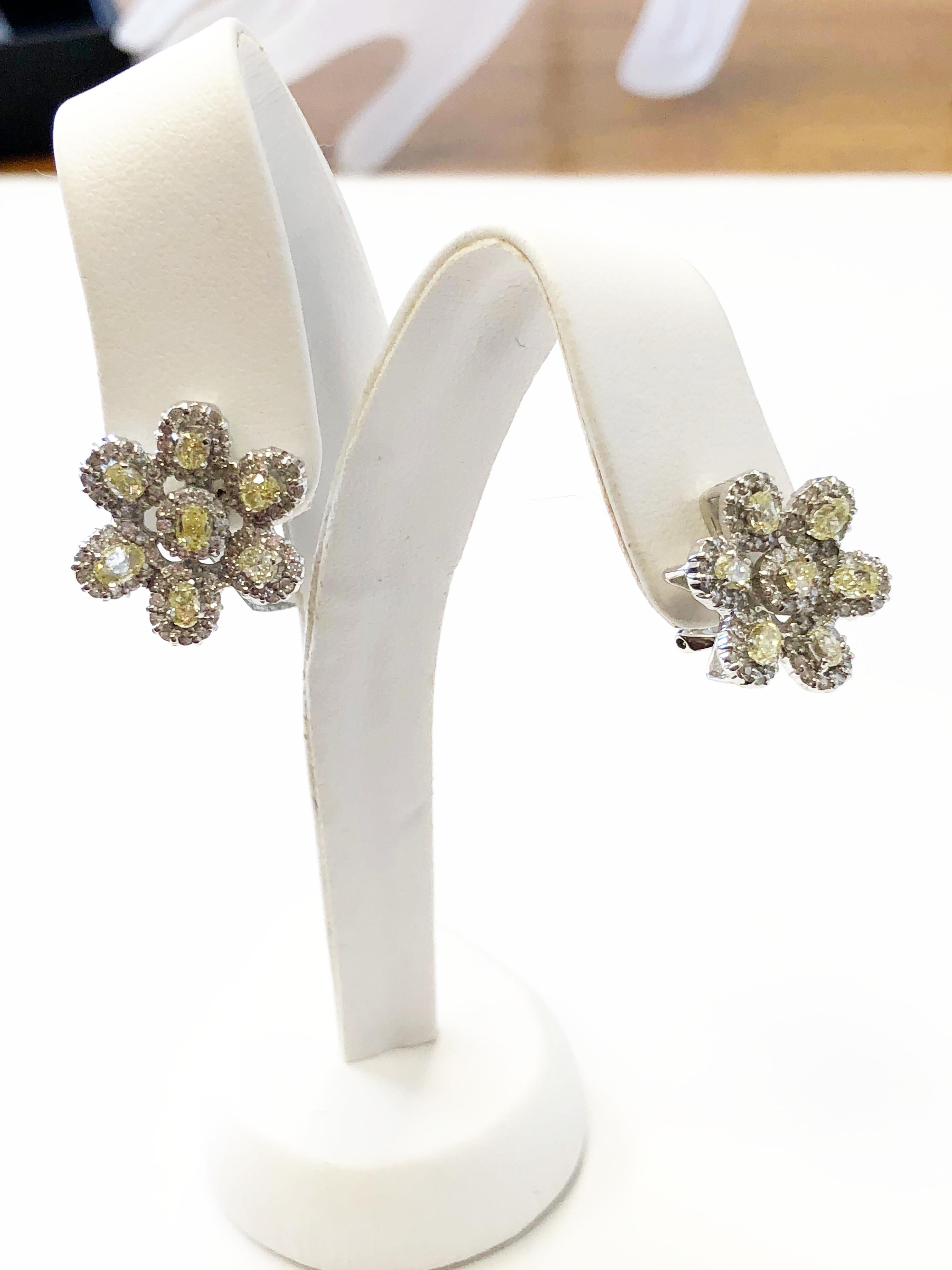3.80 carats of gorgeous bright yellow and white diamond rounds and ovals in a floral design.  These earrings have a french clip back and are in 18k white gold.  Perfect for an evening out, these earrings will elevate any outfit. 