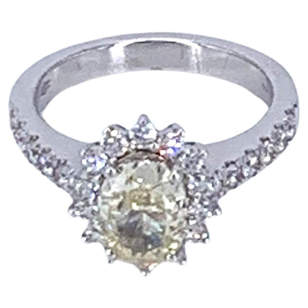 This GIA Certified 1.64 Carat Yellow Diamond & 0.60 Carat White Diamond ring, is set in 18kt White Gold. 
With a flower setting, White Diamonds framing the Yellow Diamond nestled in the bud, with half pave Diamonds dressing the ring. 
Perfect for an