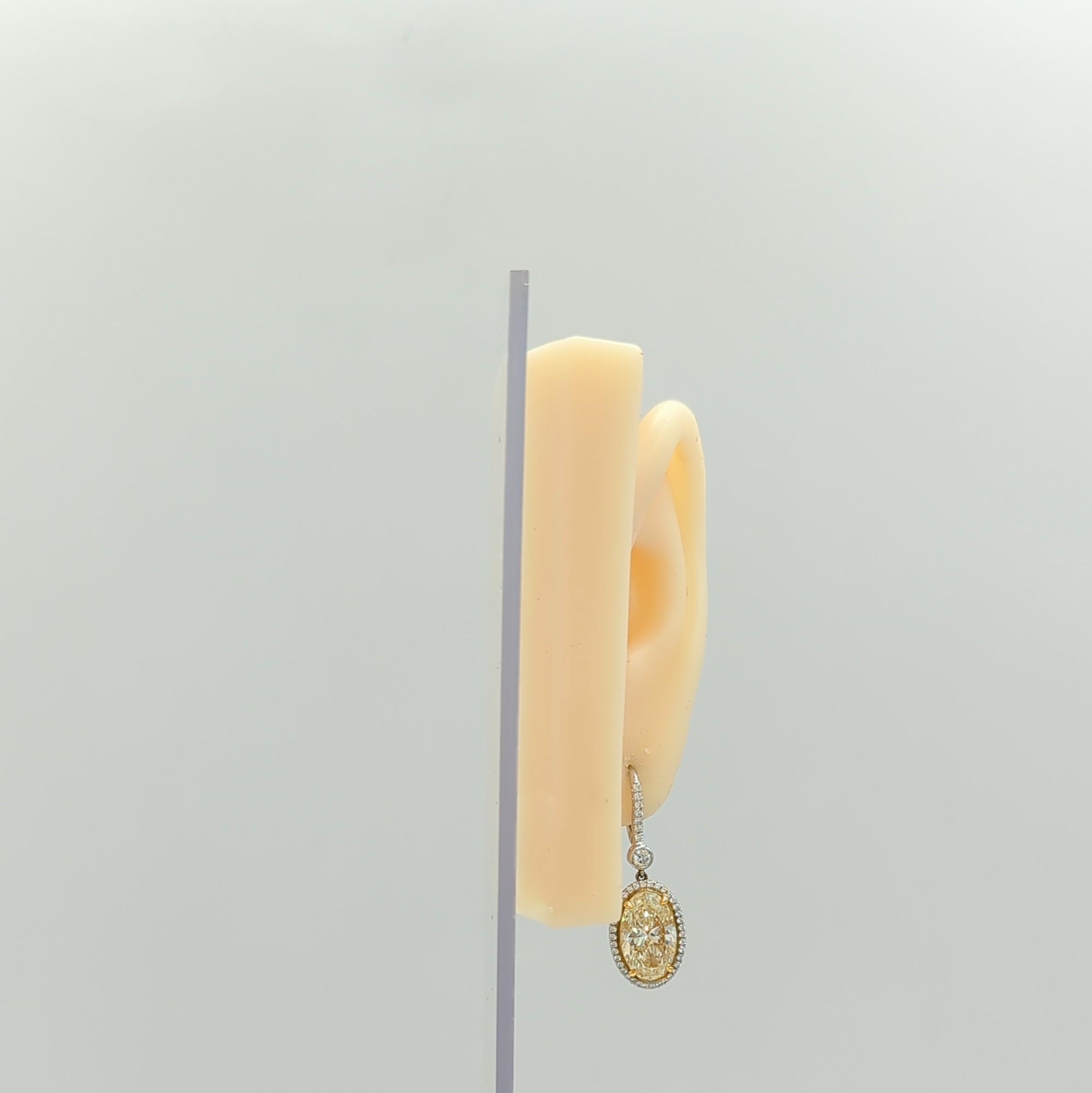 Gorgeous 5.09 ct. and 5.01 ct. diamond ovals with good quality, white, and bright diamond rounds.  Handmade in 18k white and yellow gold.  

