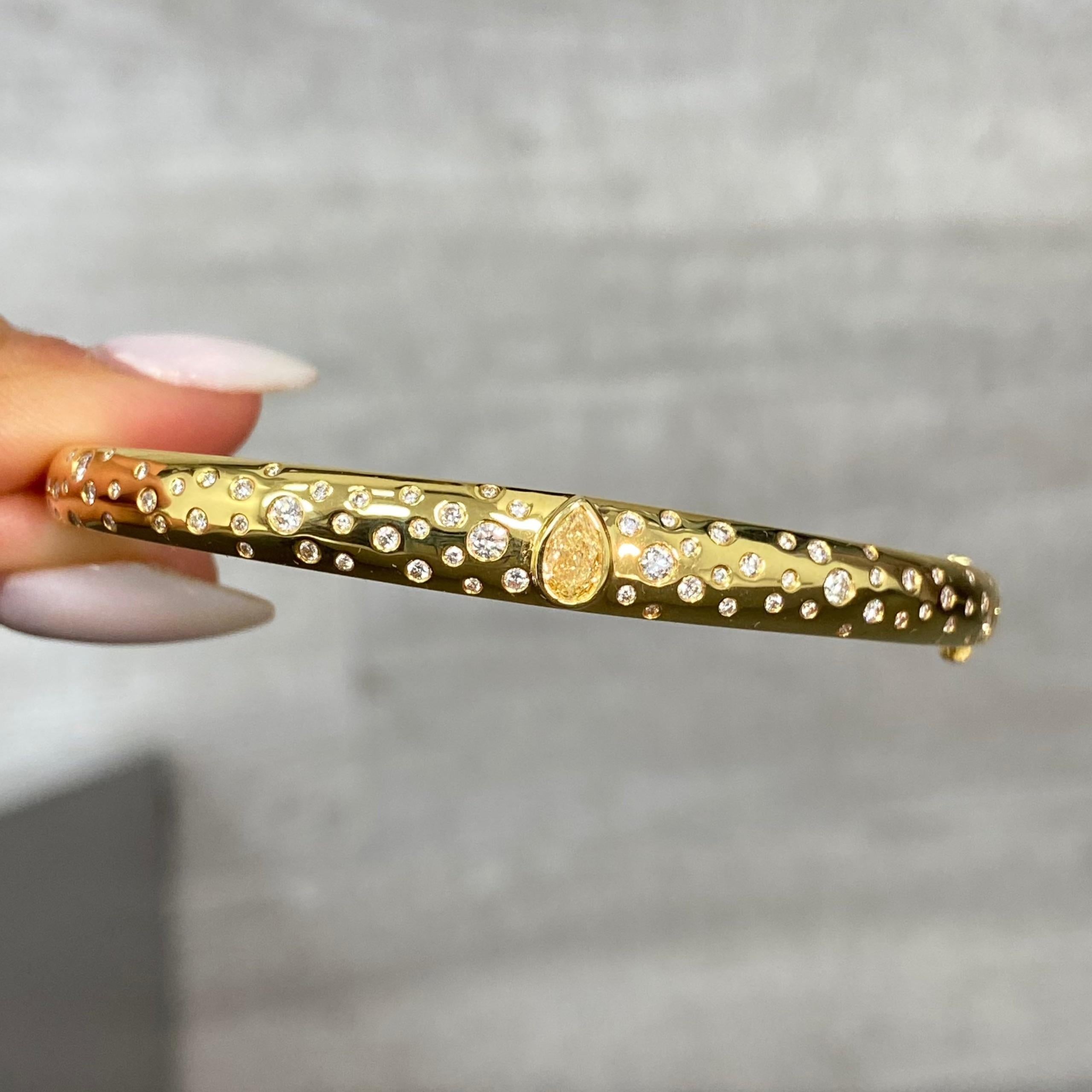 0.94 Carats Total of Diamonds
0.28 Carat Yellow Pear Shape Diamond
0.66 Carats of White Round Diamonds 
Crafted in 18k Yellow Gold Domed Bangle
Fits size 7 wrist
Handmade in NYC

This piece can be viewed before purchase in our showroom in NYC, or at