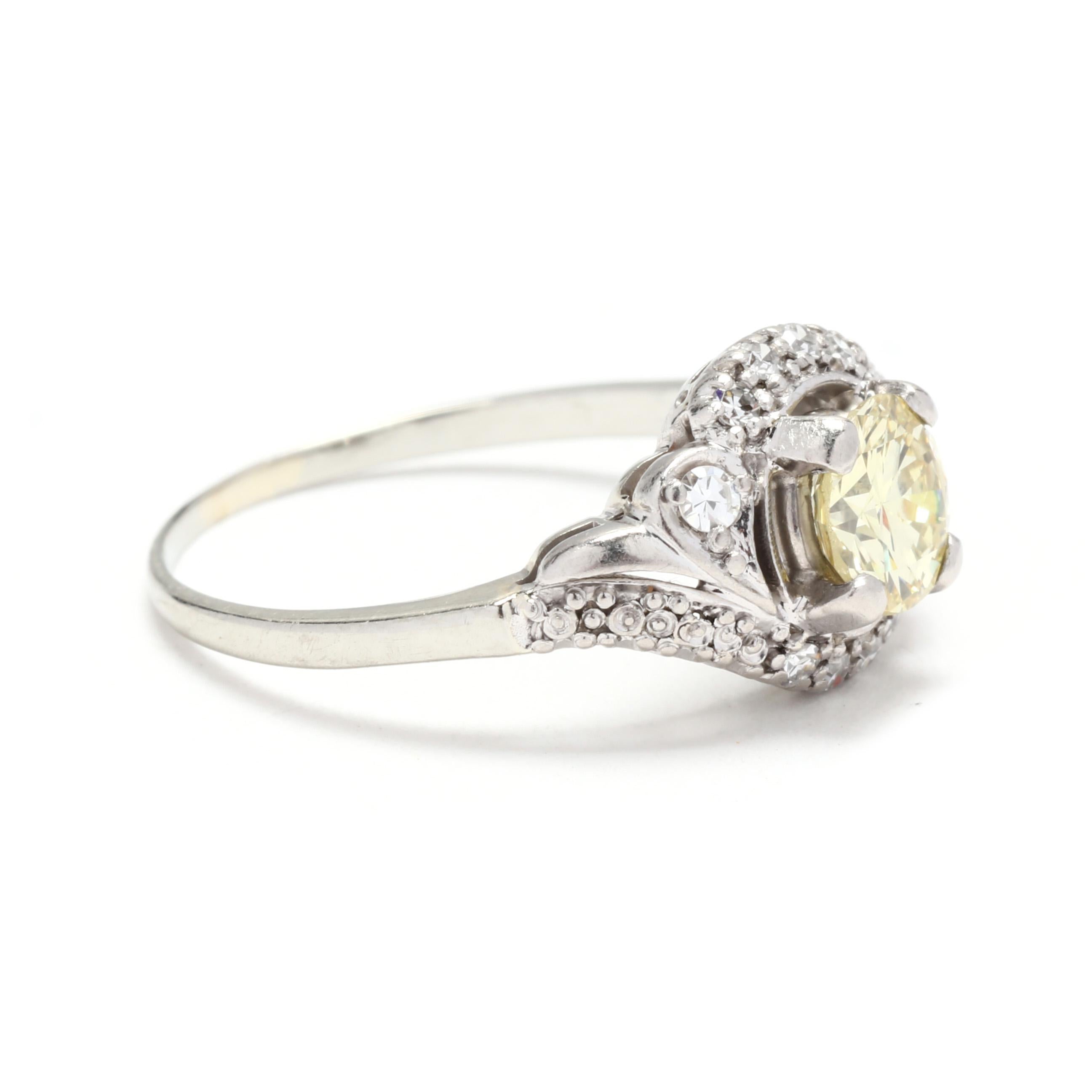 A vintage 18 karat white gold fancy yellow diamond swirl engagement ring. This retro ring features a prong set, round brilliant cut fancy yellow diamond weighing approximately .75 carat, set in a swirl motif mounting with single cut round diamonds
