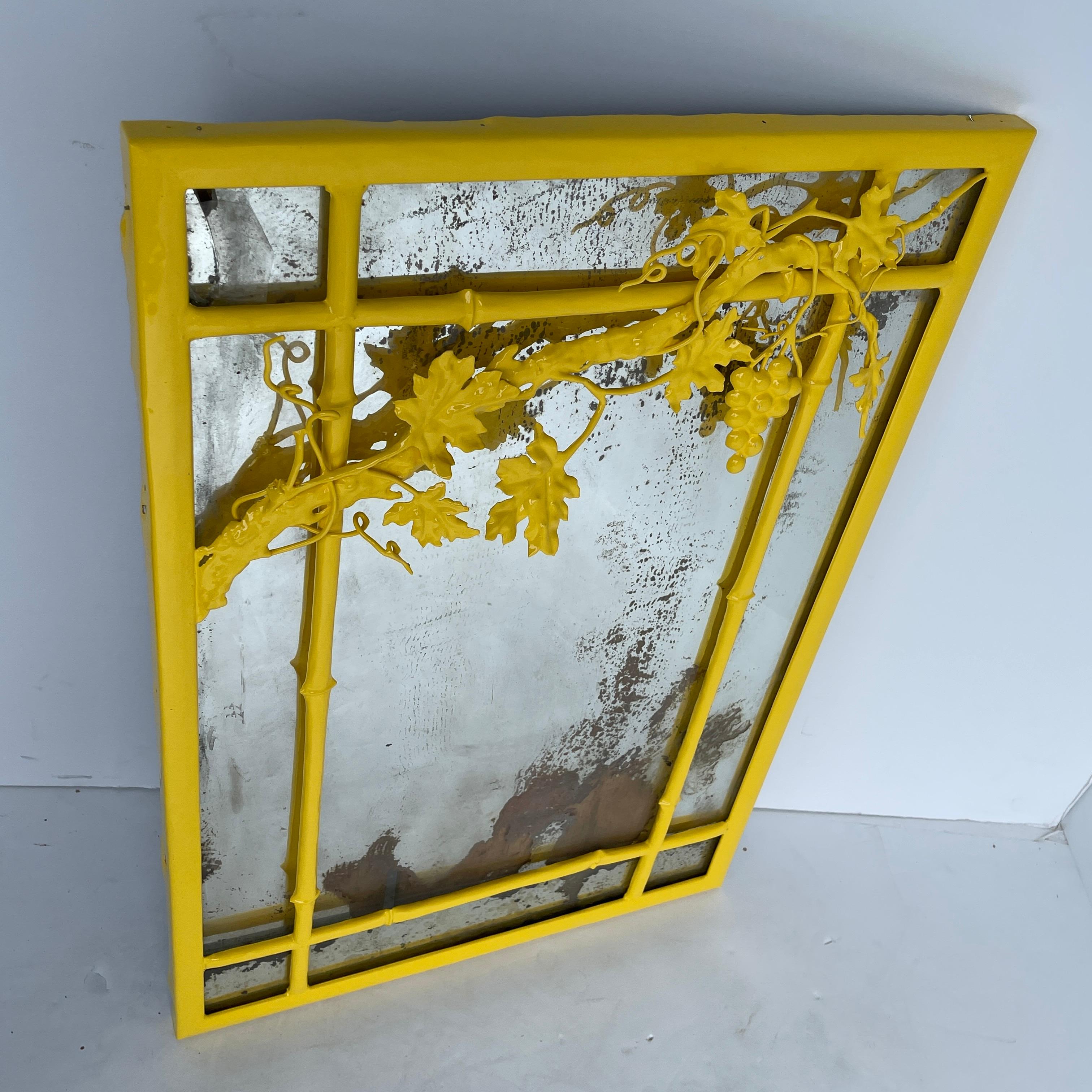 Mid-Century Modern hellen Sonnenschein gelb pulverbeschichtet lackiert Wandspiegel. 
Dieser helle und kräftige gelbe Wandspiegel im Vintage-Stil hat einen schweren Metallrahmen mit einem schön verzierten Trauben-, Blatt- und Zweigdesign. Das