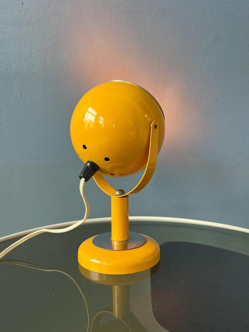 Magnifique lampe de table jaune de l'âge de l'espace avec globe oculaire. L'abat-jour du globe oculaire peut être tourné dans n'importe quelle direction souhaitable. La lampe nécessite une ampoule E14 et dispose actuellement d'une fiche UE