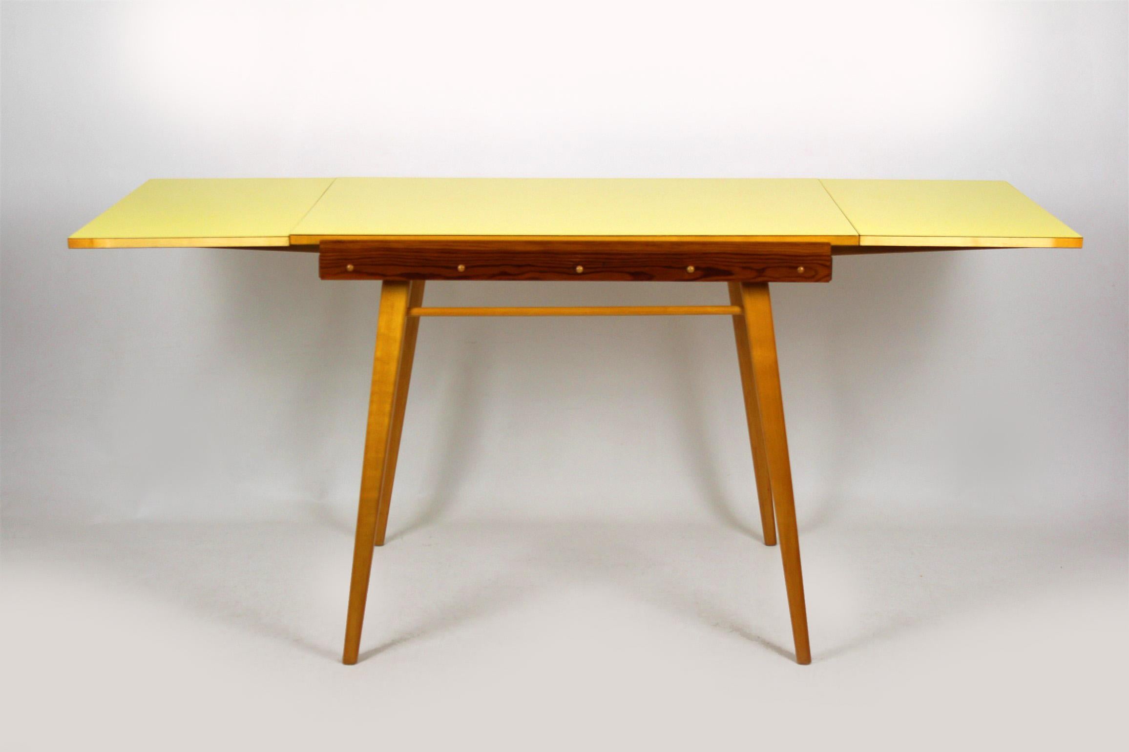 Yellow formica folding dining table, manufactured in 1960s in Czechoslovakia. The table measures 169cm wide when fully extended.