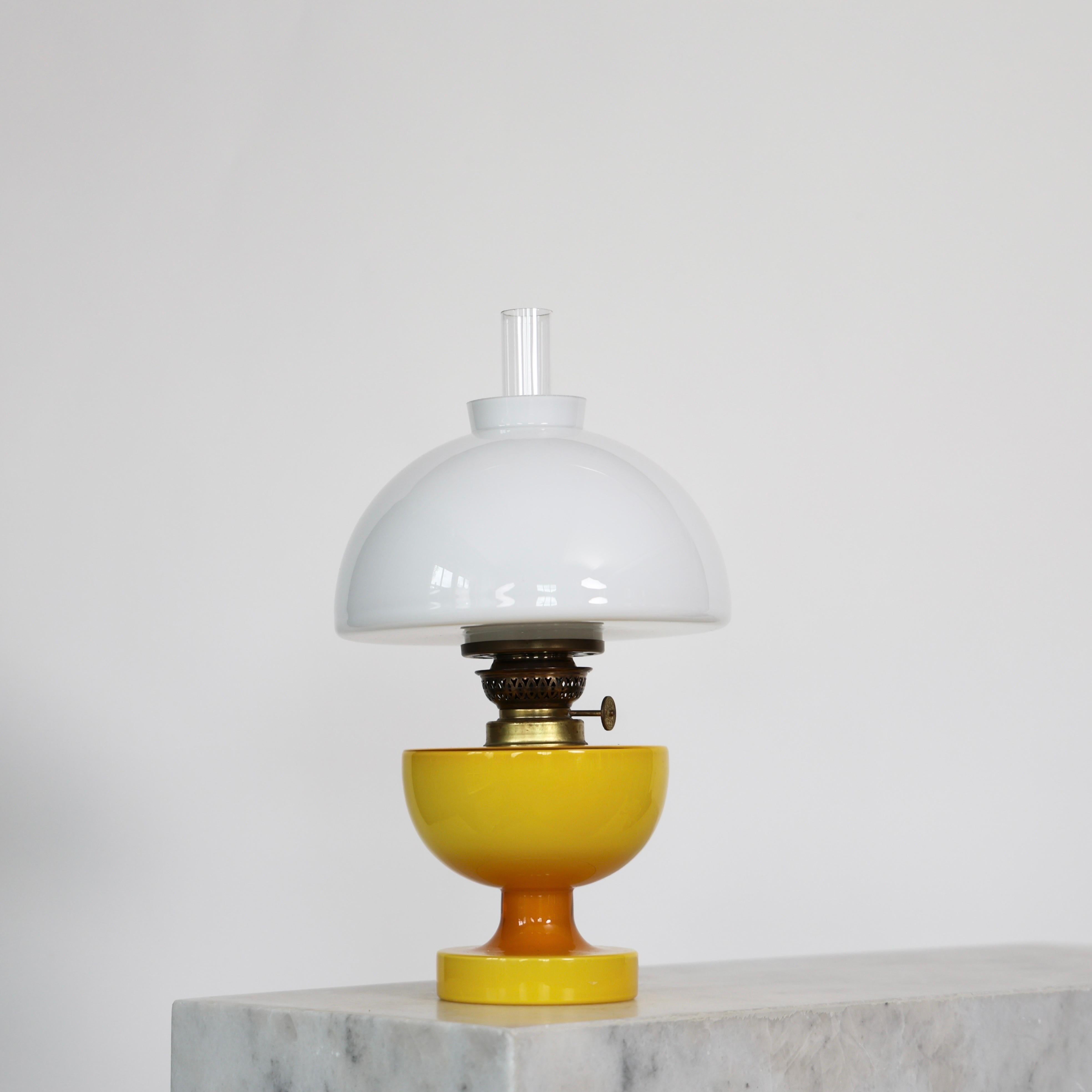 Lámpara de sobremesa de vidrio soplado amarillo y blanco diseñada por Michael Bang para Holmegaard Glasværk en 1967. 

* Lámpara de mesa de cristal amarillo con cuello de latón y pantalla de cristal blanco
* Diseñador: Michael Bang 
* Estilo: