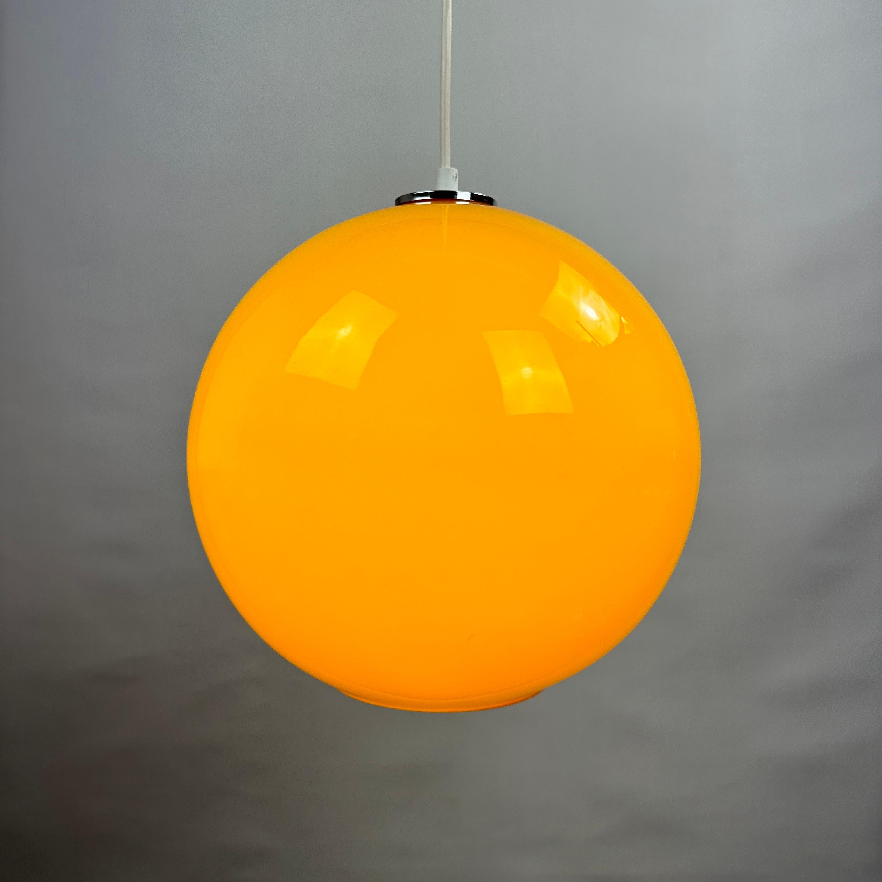 Cool large globe / sphere shaped yellow opaline glass pendant light is made by the German company Peill and Putzler around the 1960's. Has a yellow color and gives a very nice soft light.

Beautiful retro color but still fits in an everyday