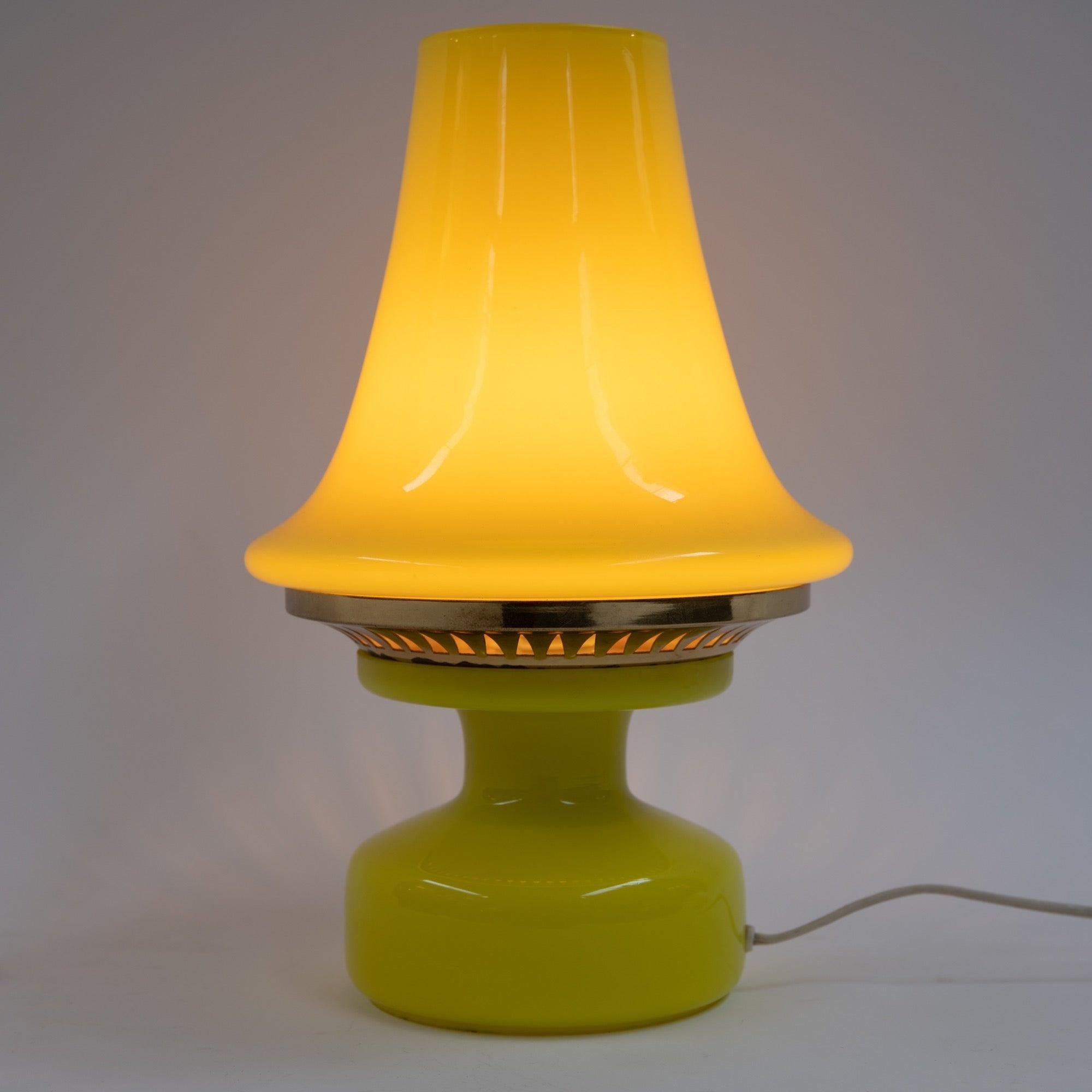 A yellow blown glass lantern style table lamp