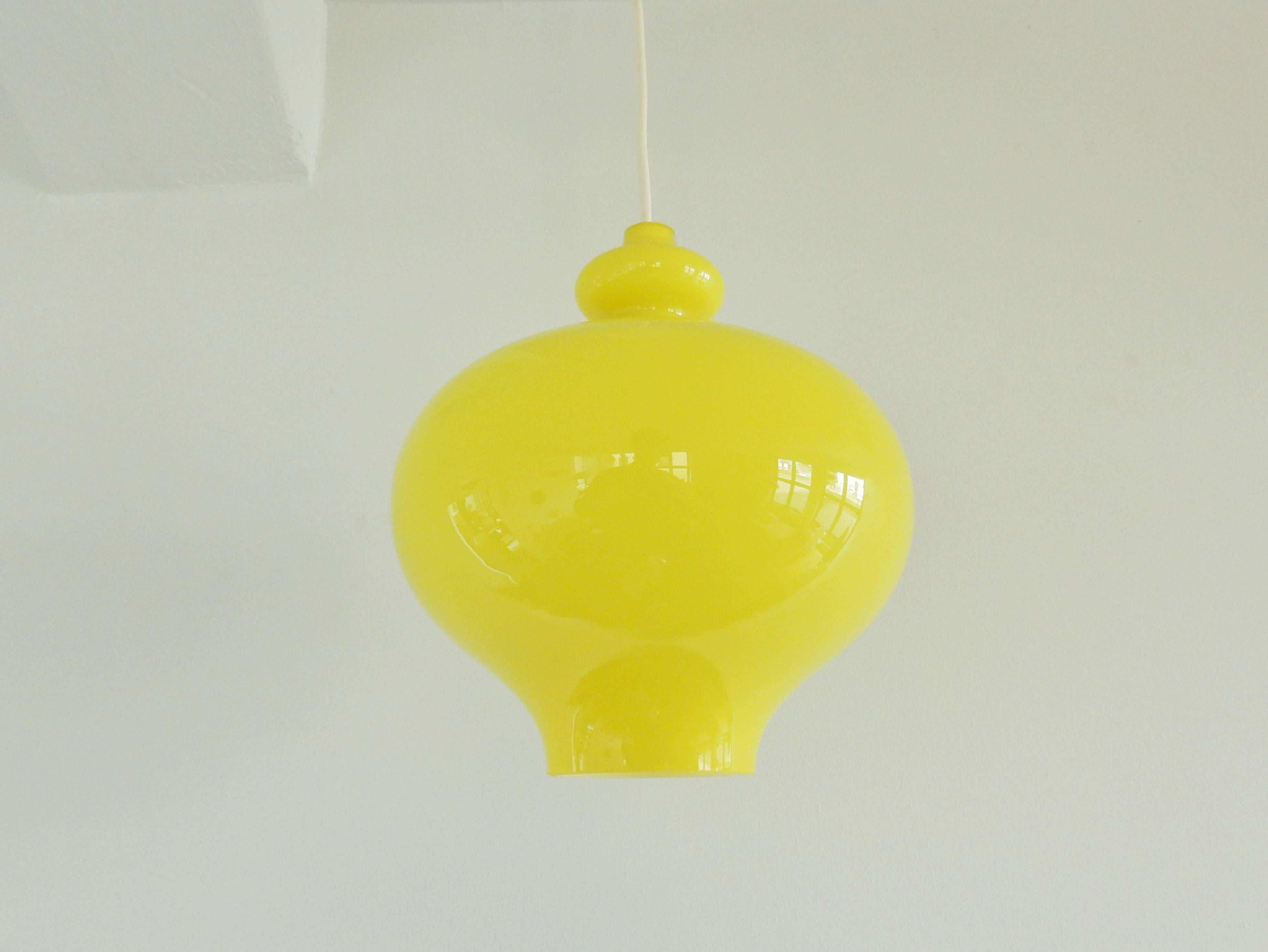 Bright yellow colored glass pendant lamp with an opaline inside for a beautiful softened light. This light is in a very good condition.