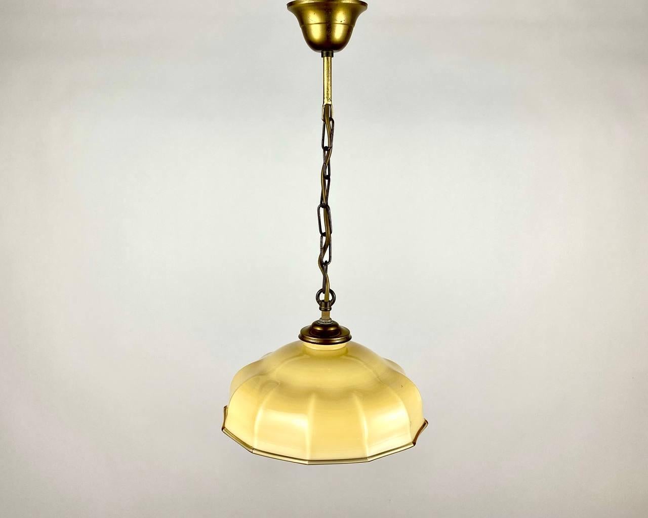 Yellow glass hanging lamp with brass fixture from the 1960s.
The glass shade has a bit of the shape of an umbrella. 

Unusual vintage chandelier from France, 1960s'.

A golden wire is 