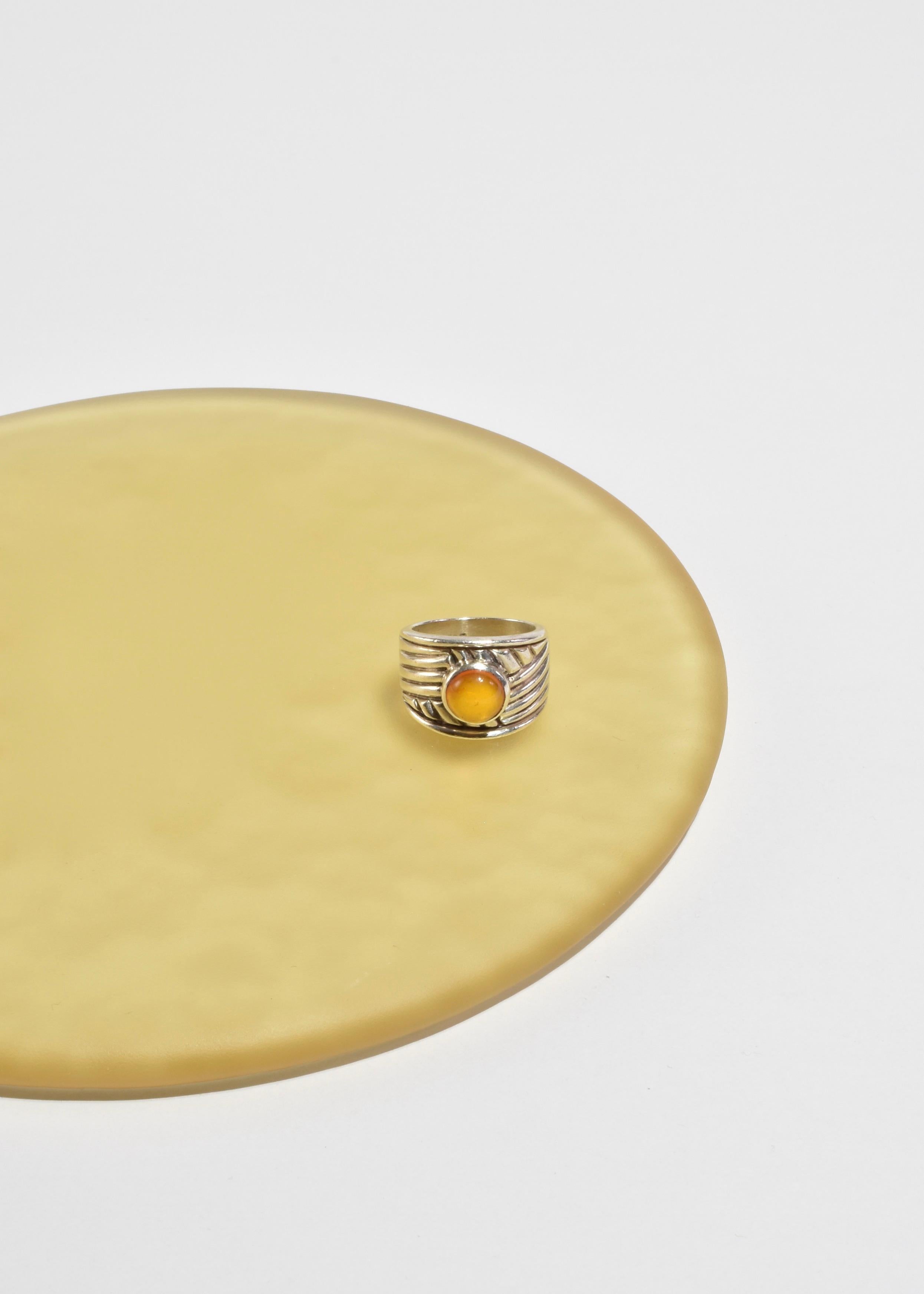 Vintage silver ring with a decorative wide ribbed band and a round yellow glass cabochon. Stamped 925.

Material: Sterling silver, glass.
