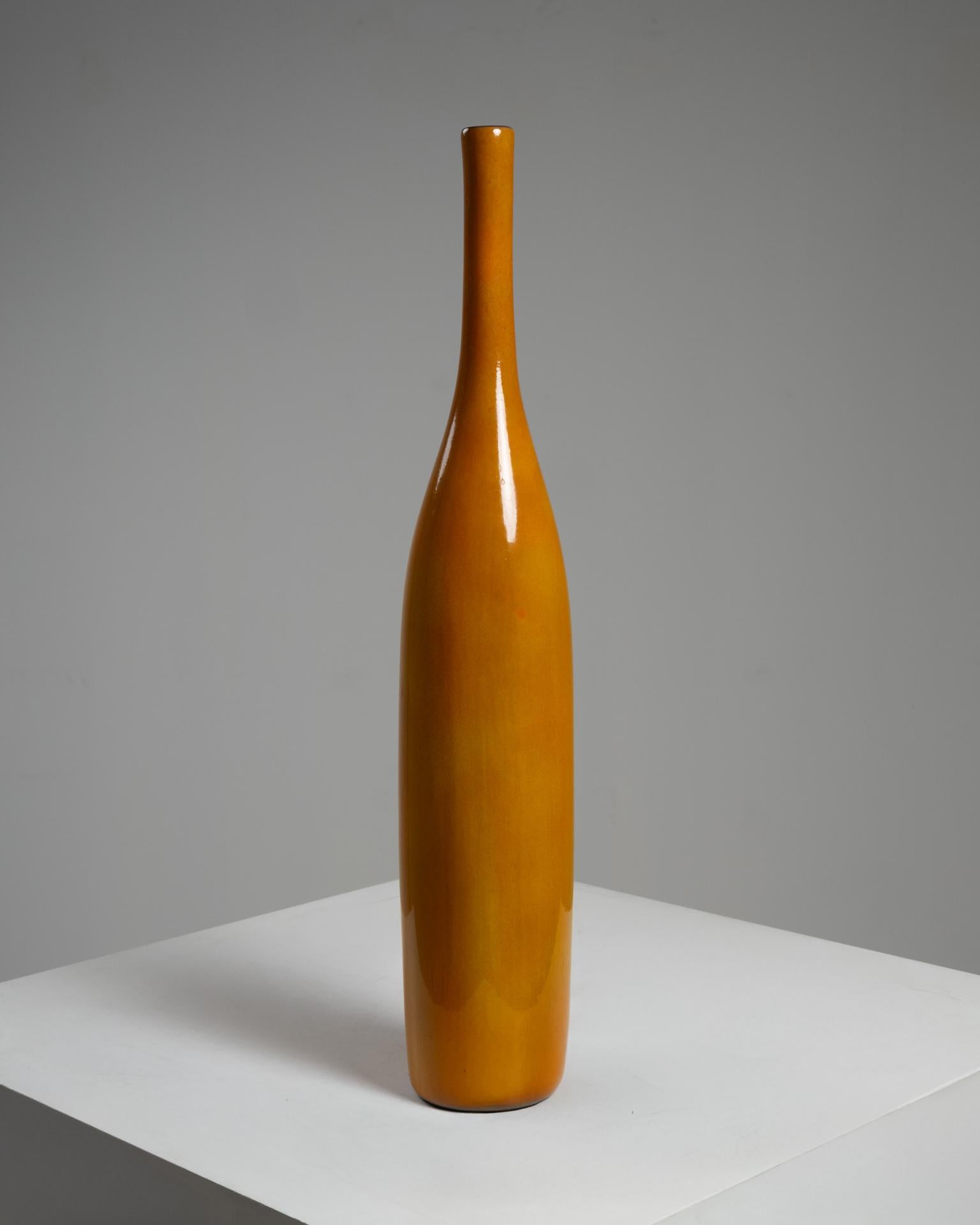 Este llamativo jarrón de cerámica esmaltada amarilla fue diseñado por Jacques (1926-2008) y Dani (1933-2010) Ruelland, uno de los dúos más célebres del arte cerámico francés de posguerra. Creada en Francia hacia 1960, esta pieza alta y elegante