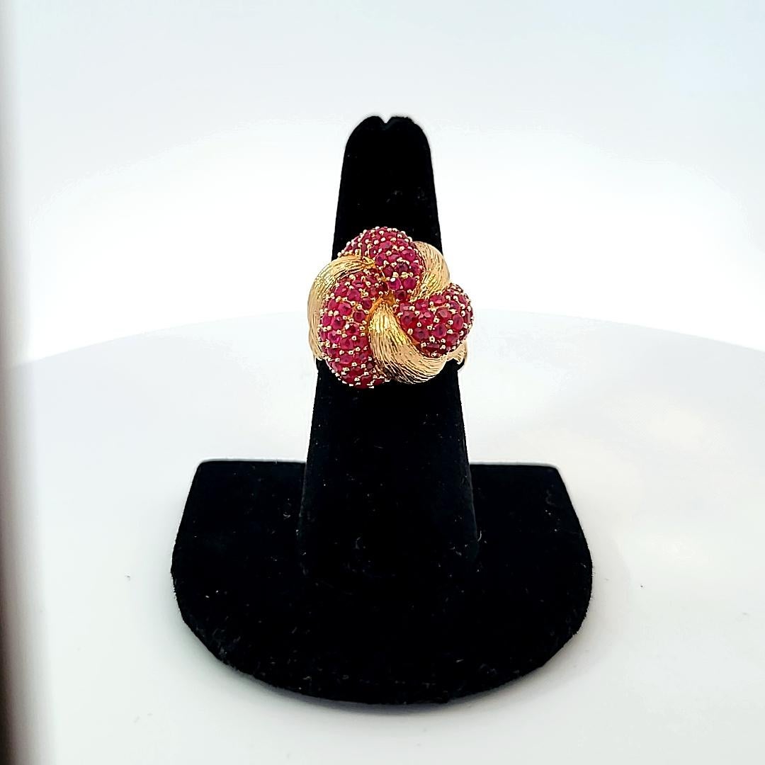 In lovely textured 14 karat yellow gold, this knot ring is a stunner and supports 5.00 carats of round rubies!