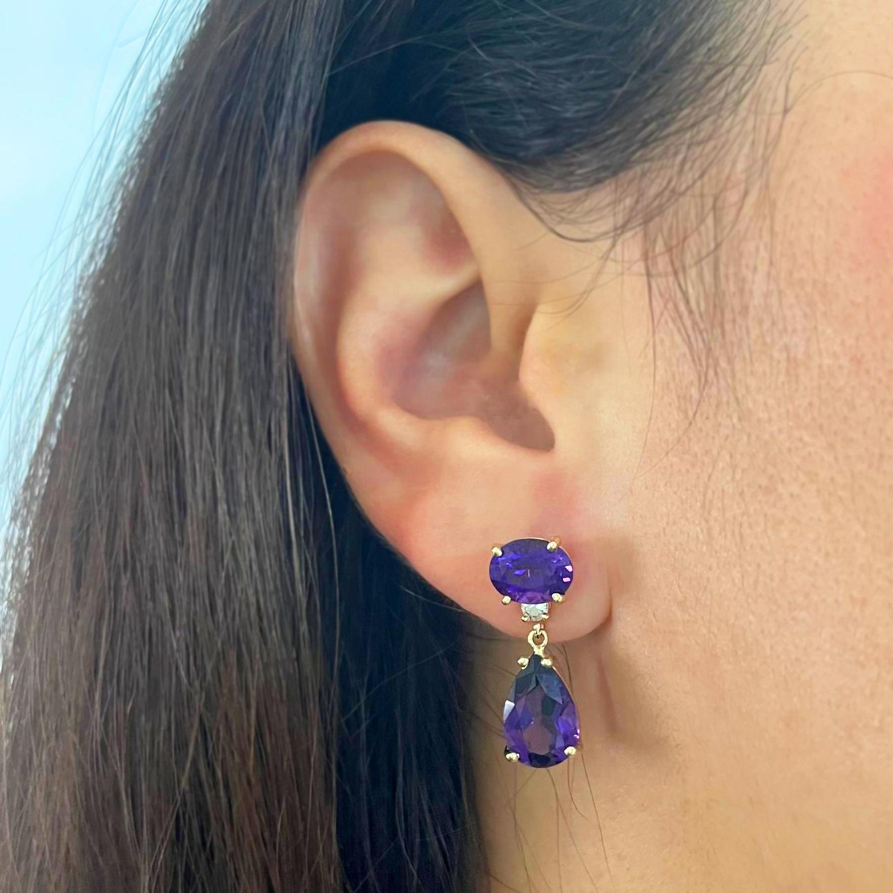 14 karat yellow gold detachable drop earrings featuring 2 pear cut and 2 oval cut amethysts totaling approximately 7.9 carats accented by 2 round diamonds of VS clarity and J color totaling approximately 0.20 carats. 1 inch long with pierced post