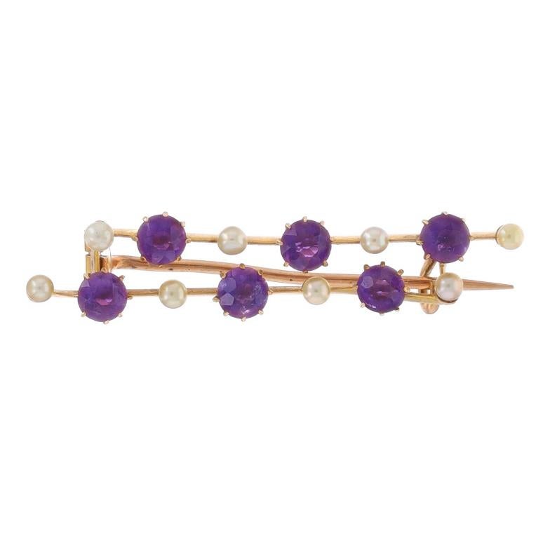 Era: Edwardian
Date: 1900s - 1910s

Metal Content: 9k Yellow Gold

Stone Information

Natural Amethysts
Cut: Round
Color: Purple

Natural Pearls

Style: Brooch
Fastening Type: Hinged Pin and C-Clasp
Theme: Double Line

Measurements

Tall: 3/8