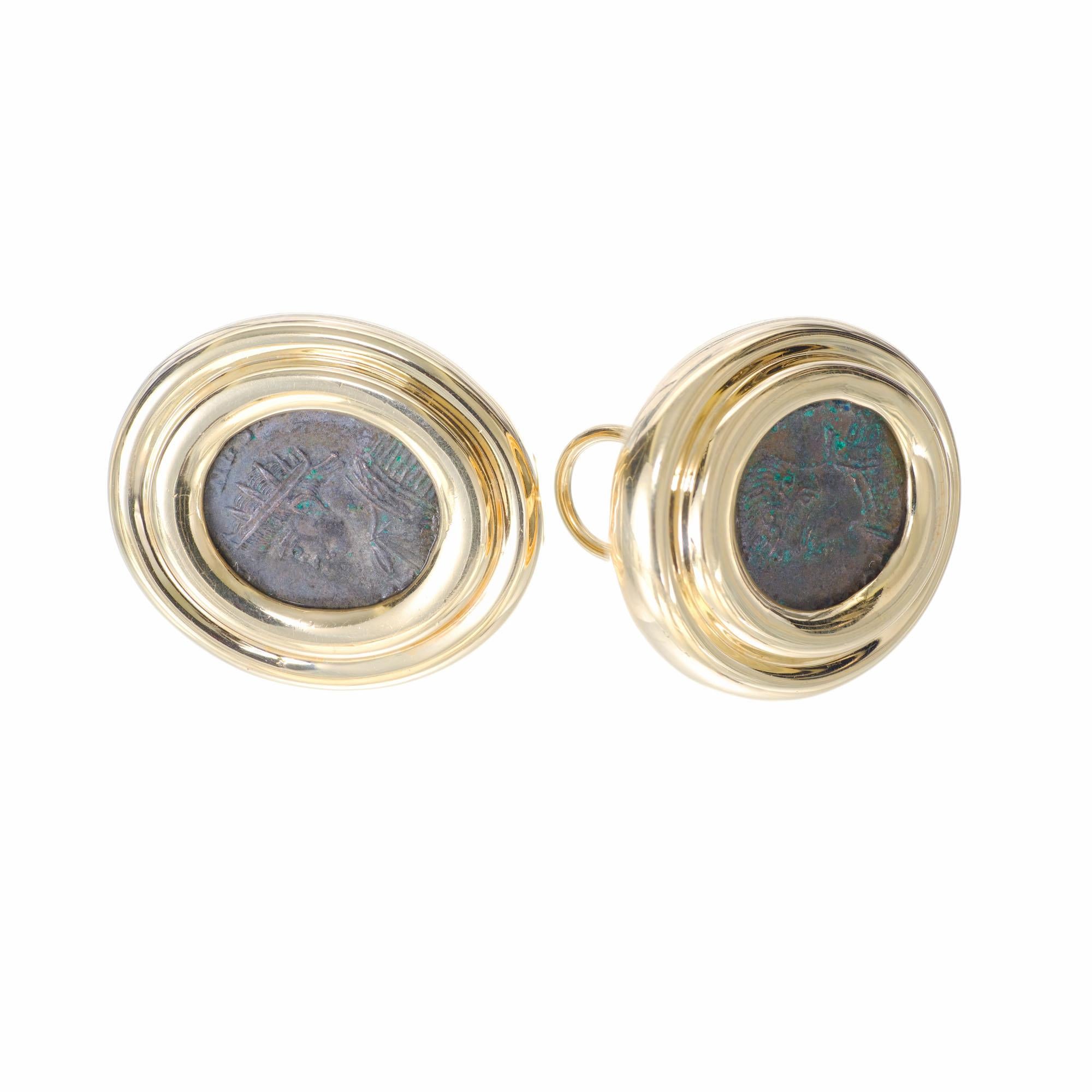 Oval clip post 14k yellow gold clip post earrings set with a matched pair of ancient coins. 

14k yellow gold 
Stamped: 14k
Top to bottom: 28.65mm or 1 1/8 Inch
Width: 25mm or 1 Inch
Depth or thickness: 6.1mm
