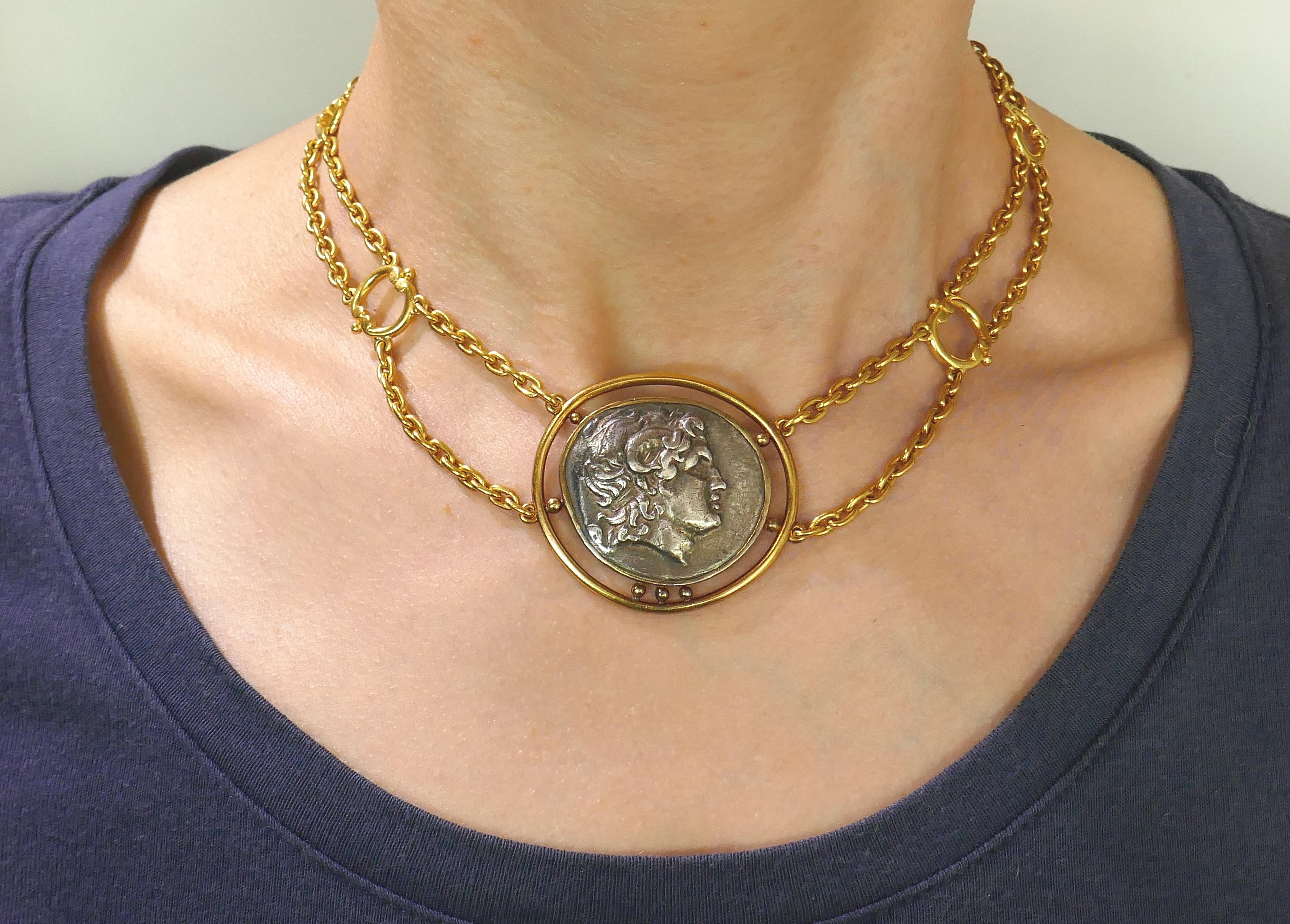 Beautiful coin necklace featuring an ancient Greek coin created by Helen Woodhull in 1979. Trendy, elegant and wearable, the necklace is a great addition to your jewelry collection.
The coin measure 1-1/4 x 1-1/8 (3.2 x 2.9 centimeters). The rest of
