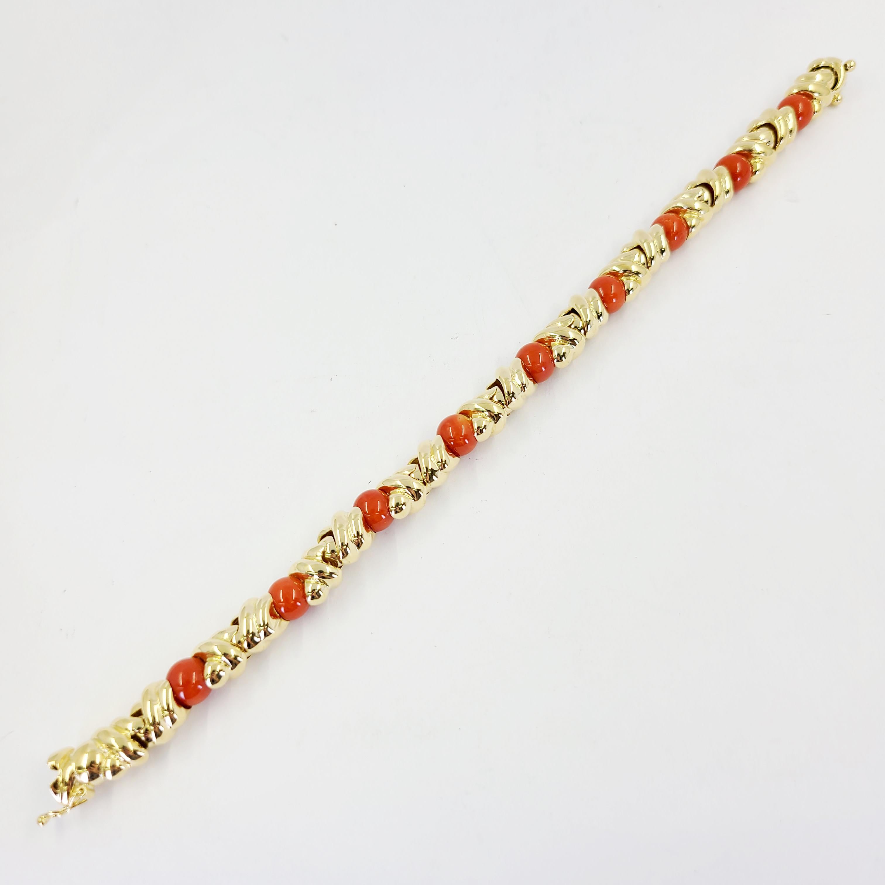 18 Karat Yellow Gold Link Bracelet Featuring 9 Round 8mm Coral Beads. 8.5 Inches Long With Hidden Box Clasp and Figure 8 Safety. Finished Weight Is 33.4 Grams. Made in Italy. Matching Necklace Also Available Separately.