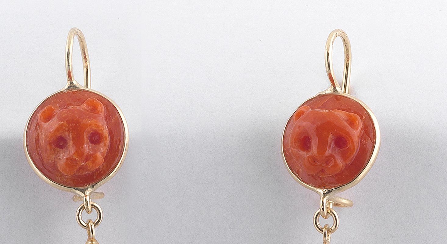 

18kt yellow gold with corallium rubrum earrings. On the top lion cameo corallum suspending corallum drop
Lenght : 5cm
Weight:  5.8gr.