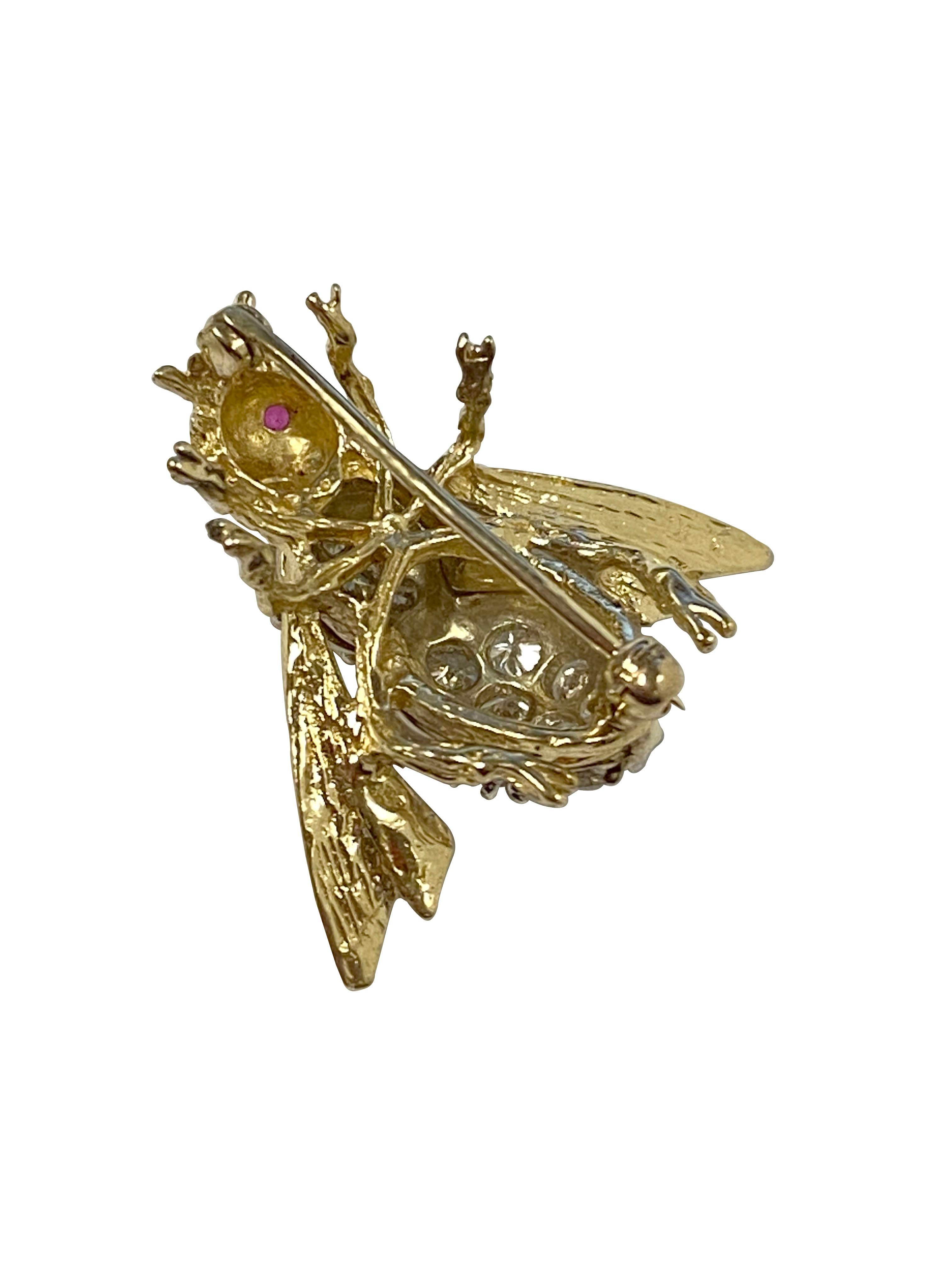 Circa 1980s 14k Yellow Gold Bee Brooch, measuring 1 inch in length and 1 1/8 inch wide, set with Round Brilliant cut Diamonds totaling 1.50 Carats and Grading as G in color and VS in Clarity. Further set with Ruby eyes, hand textured and detailed