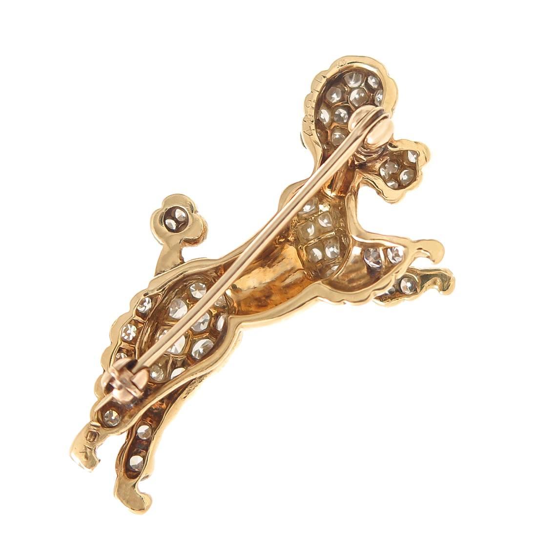 Circa 1960s 18K Yellow Gold Poodle brooch, measuring 1 1/4 inch in length and set with Round Brilliant and single cut Diamonds totaling 1 Carat as Grading as G- H in color and VS in Clarity, further set with a Ruby in the Eye. An extremely well made