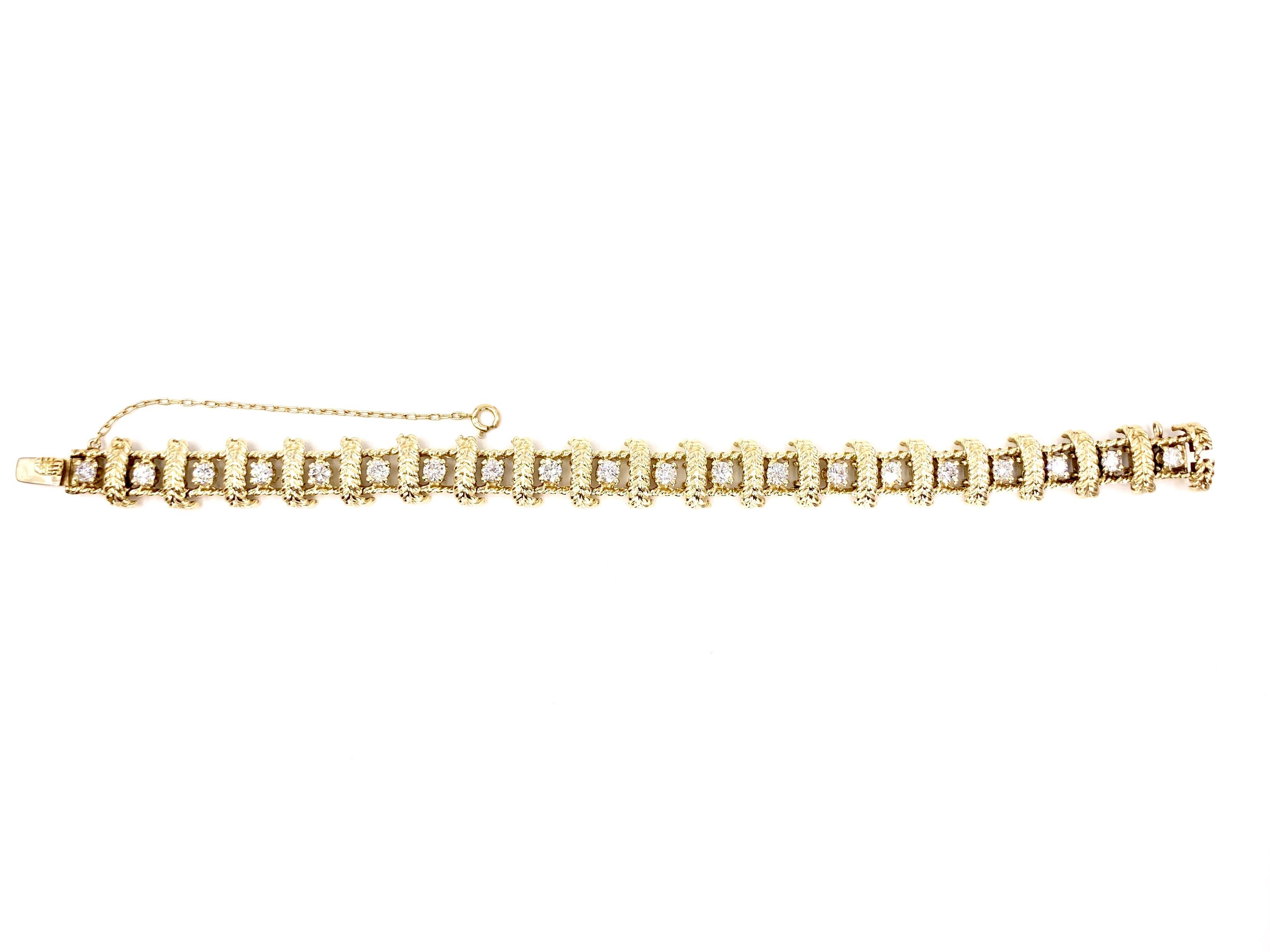 Circa 1960's, this unique textured 14 karat yellow gold and diamond bracelet features 20 round brilliant diamonds at approximately 2.40 carats total weight. Each link features a vertical gold leaf design between each diamond. Bracelet closes