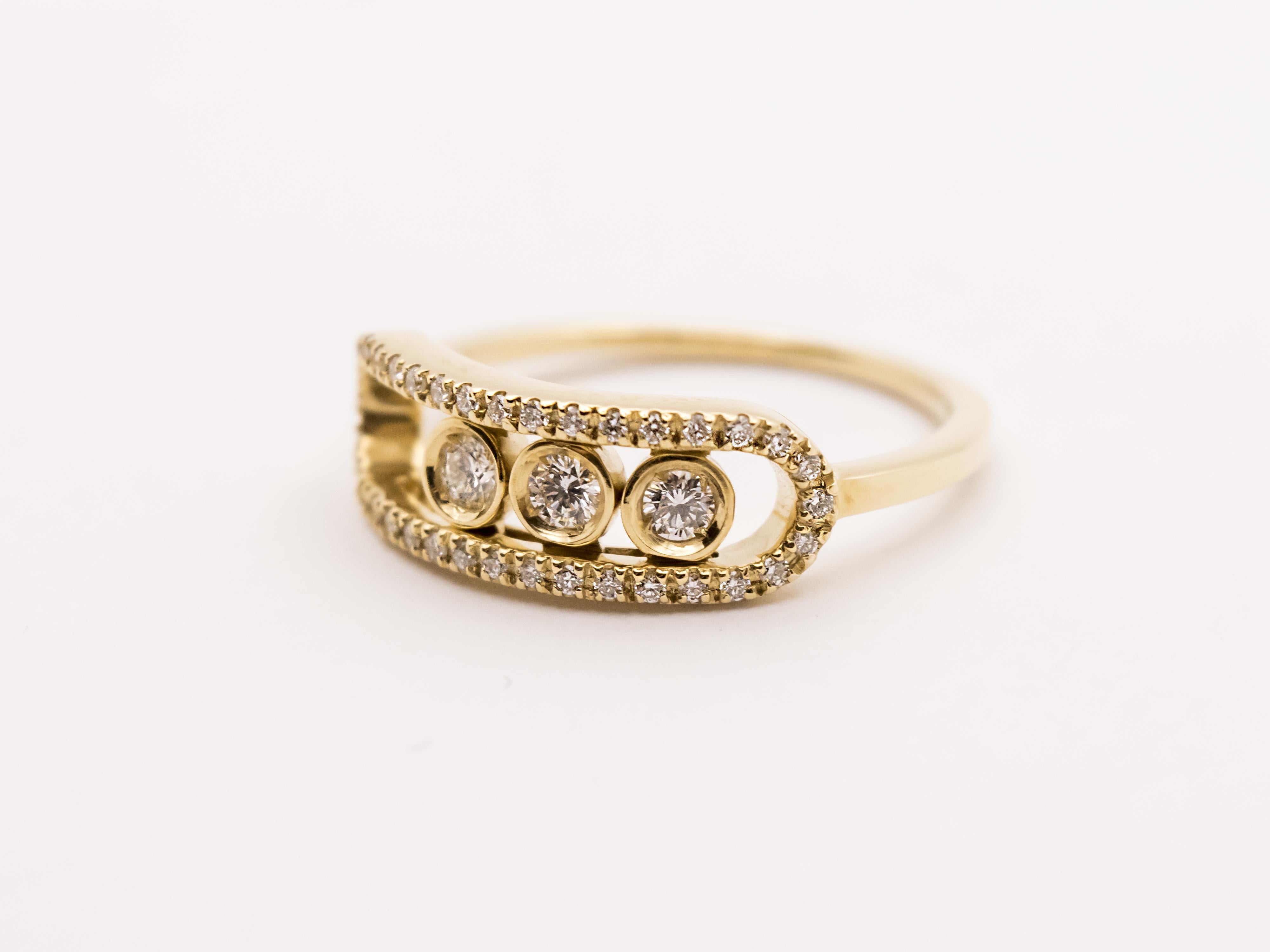 This is an Italian hand-made 18Kt yellow gold ring.
It has a oval frame at the center enhanced by precious diamonds.

Throughout the frame there are three bigger diamonds fitted on three different round moving settings.
Thanks to its fancy style