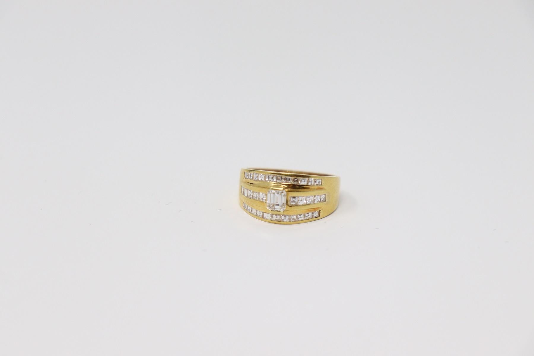 18 Karat yellow gold ring with 0.70 Cart Central Diamond. Other diamonds on the sides carré cut total about 0.45 Carats. 
Total weight: about 5.90 g.
New contemporary jewelry. Produced in the famous Italian city of gold Valenza. 
Ring size Italian