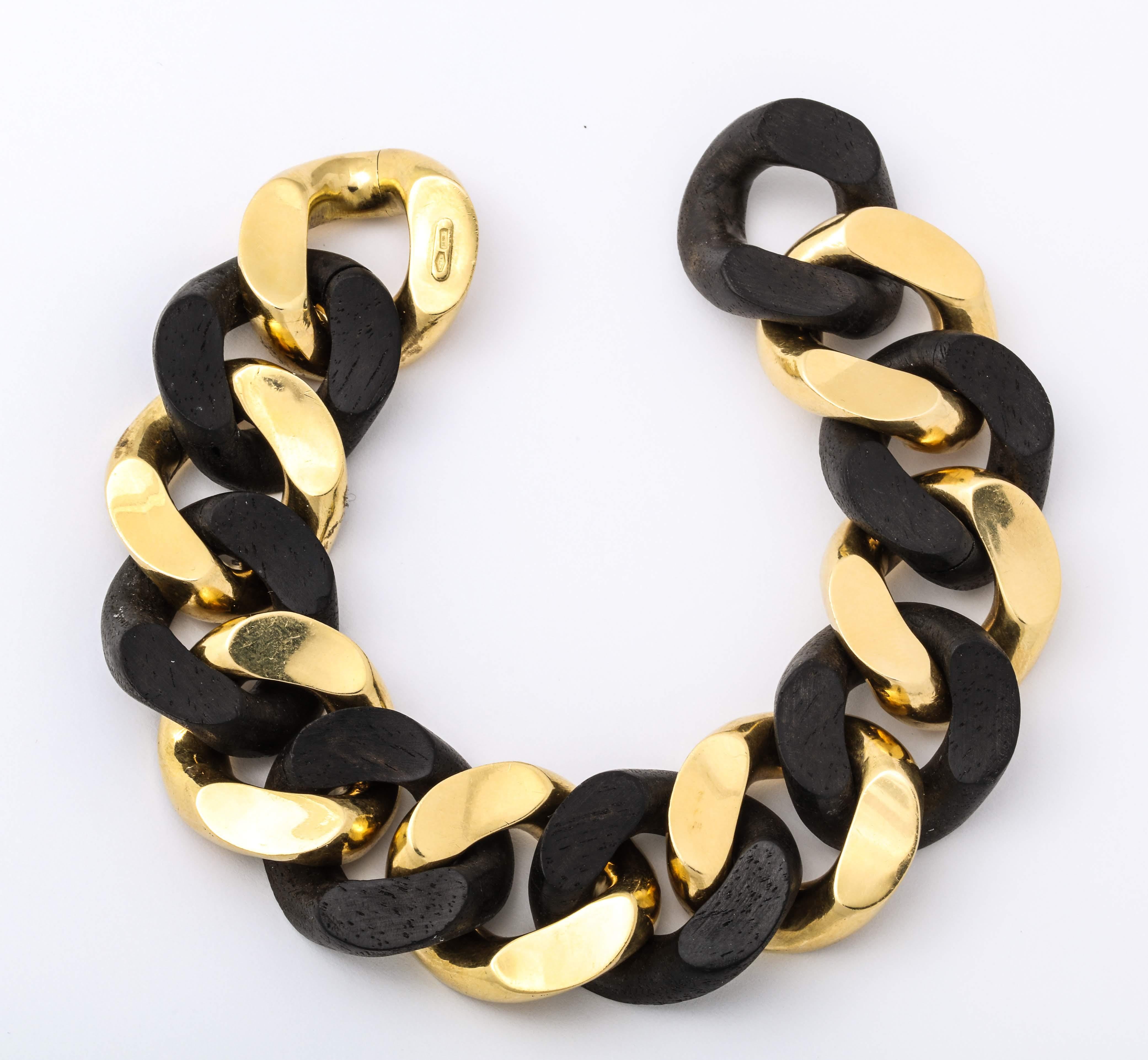 Urban and chic 18K yellow gold concave curb links alternating with convex ebony wood link bracelet.

Dimensions: Length: 8 inches  Width: 15/16 inches  Elevation: 1/4 inches

Matching necklace, sold separately.