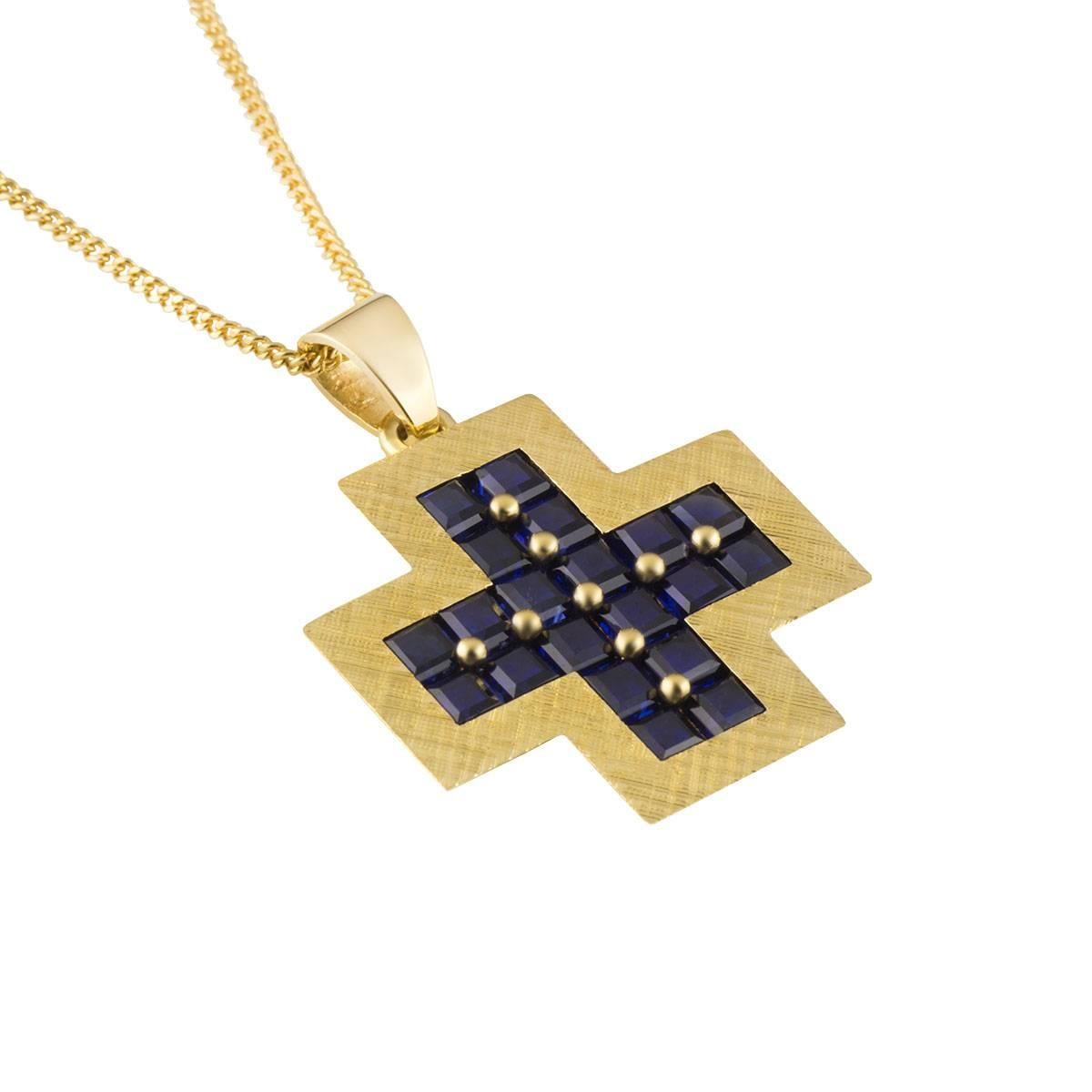 A beautiful 18k yellow gold sapphire pendant. The pendant comprises of a cross motif with 20 princess cut sapphires in a claw setting, with a total weight of approximately 2.60ct, with a deep blue hue throughout. The pendant measures 26mm in height