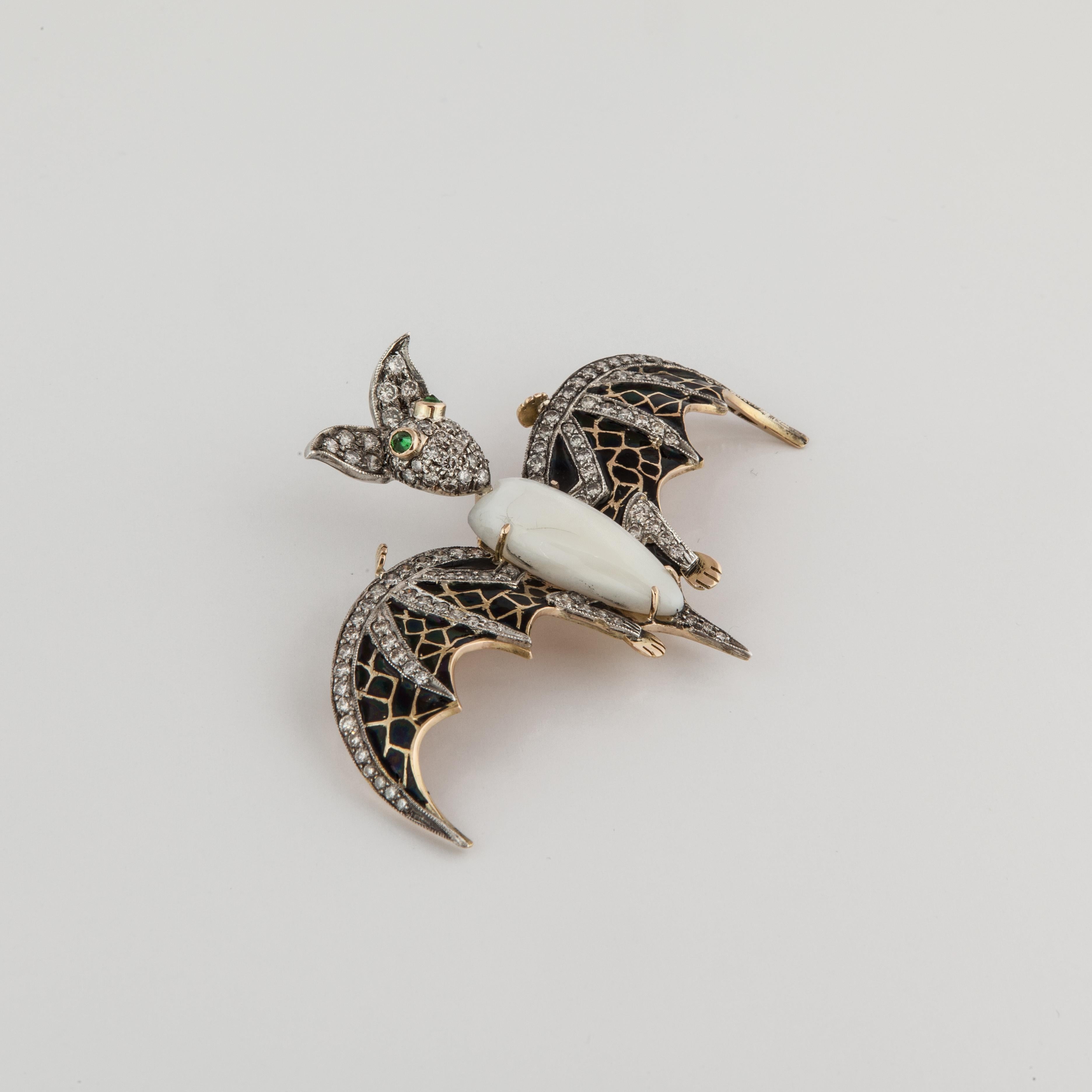 18K yellow gold and sterling silver bat pin.  The wings are enameled in black with diamond highlights (total diamond carat weight is 2.30).  The eyes are round emeralds and the body is mother of pearl.  Measures 2-7/8