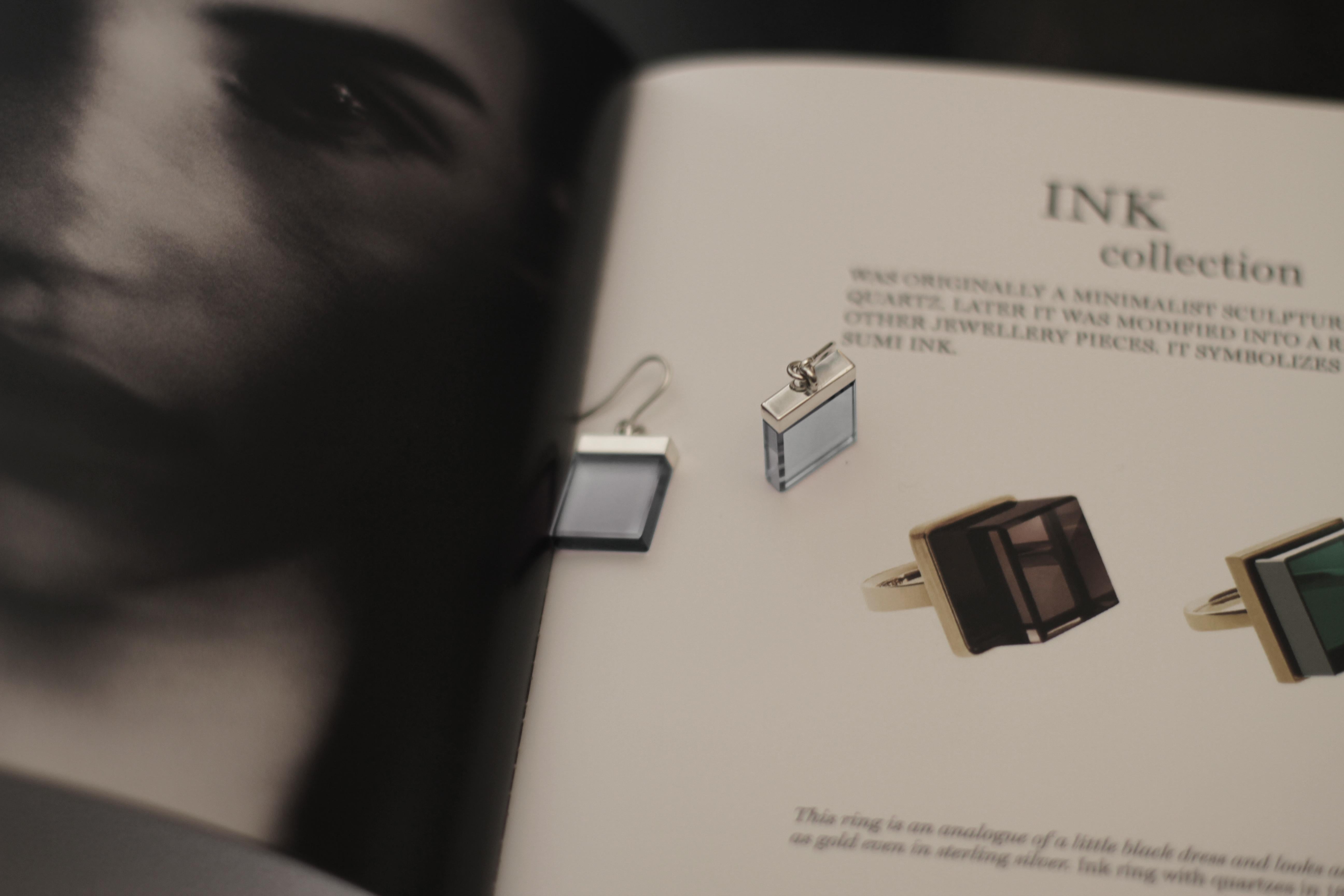 These earrings from the Ink collection have been featured in Harper's Bazaar UA and Vogue UA, and are made of 18 karat yellow gold in an Art Deco style designed by oil painter from Berlin, Polya Medvedeva.

The earrings have 15x15x3 mm blue natural