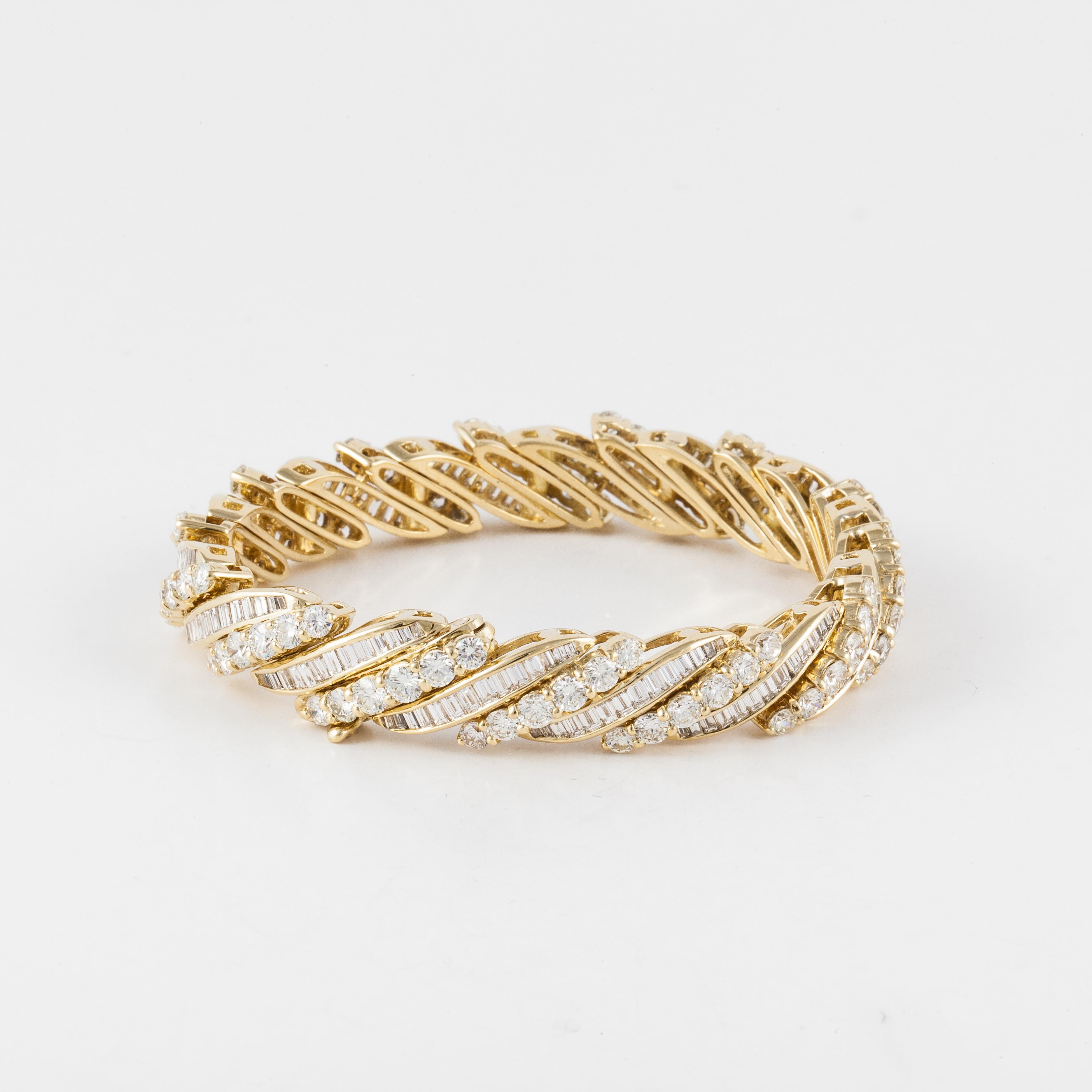 18K yellow gold bracelet featuring both round and baguette diamonds.  There are 84 round diamonds totaling 9.8 carats and 196 baguette diamonds totaling 4.2 carats.  Total diamond weight is 14 carats; H-I color and VS-SI clarity.  Measures 7 inches