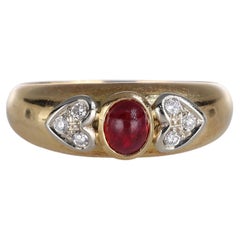 Anello a fascia in oro giallo con rubino cabochon e cuori pavé di diamanti