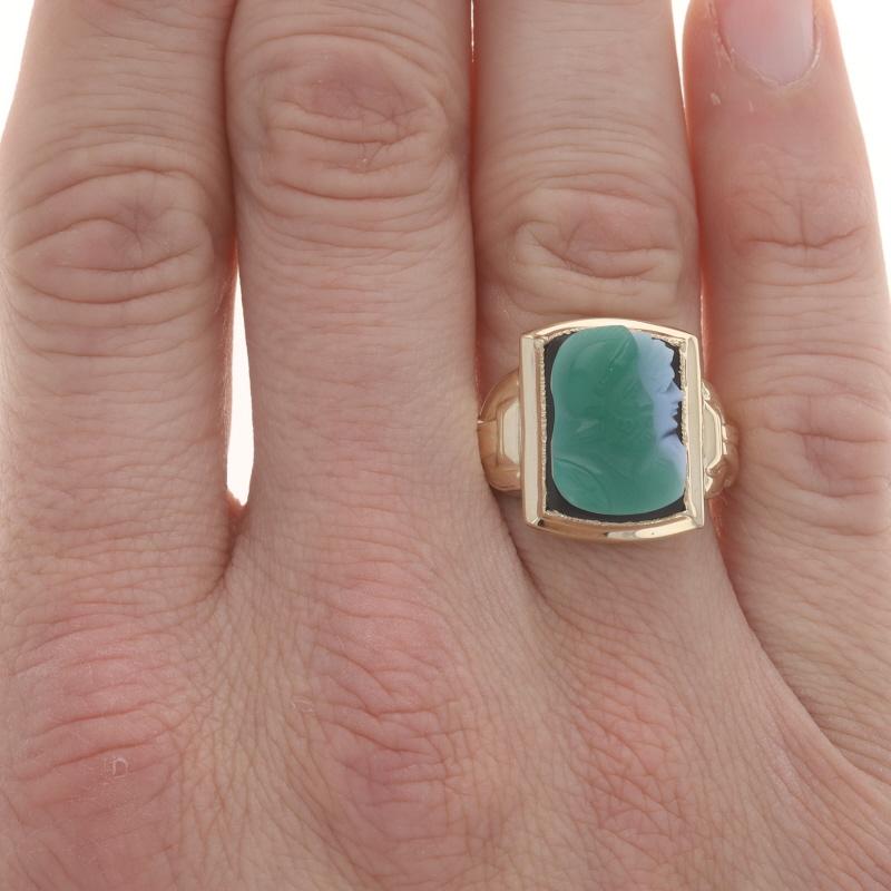 Size: 9 3/4
Sizing Fee: Up 1 1/2 sizes for $50 or Down 1 1/2 sizes for $40

Era: Vintage

Metal Content: 10k Yellow Gold

Stone Information

Natural Banded Agate
Cut: Carved Cameo
Color: Green, White, & Black

Style: Solitaire
Theme: Ancient