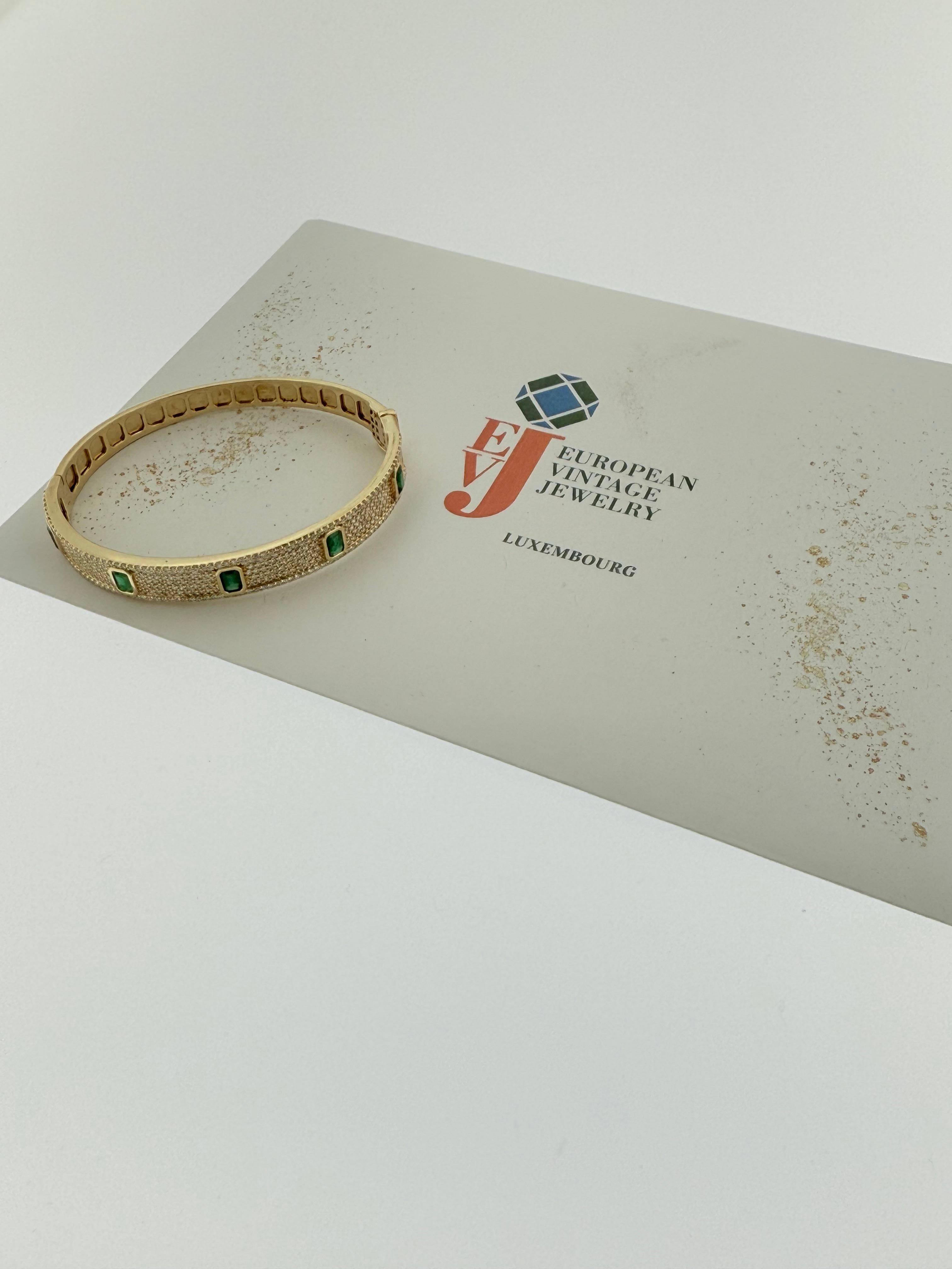 Taille : 16

Ce remarquable bracelet bangle est une véritable célébration de l'artisanat d'art et du design intemporel, créé en or jaune 18 carats et orné d'une combinaison spectaculaire de diamants et d'émeraudes. La surface du bracelet est