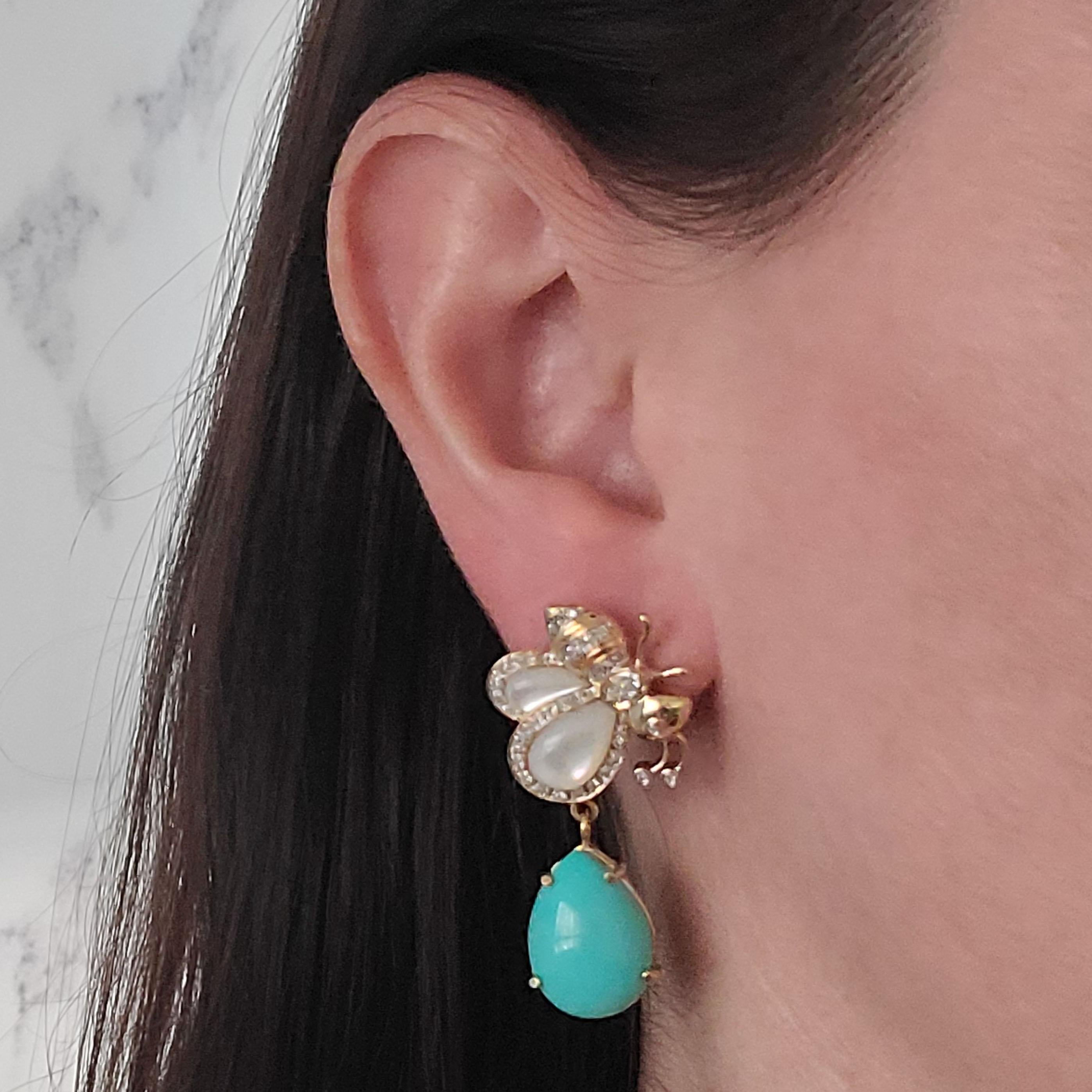Sazingg 14 Karat Yellow Gold Bee Drop Earrings Featuring Cabochon Turquoise, Mother Of Pearl, and 80 Round Diamonds Of VS Clarity & G/H Color Totaling 0.40 Carats. 1.6 Inches Long. Pierced Post With Friction Back. Finished Weight Is 11.8 Grams.