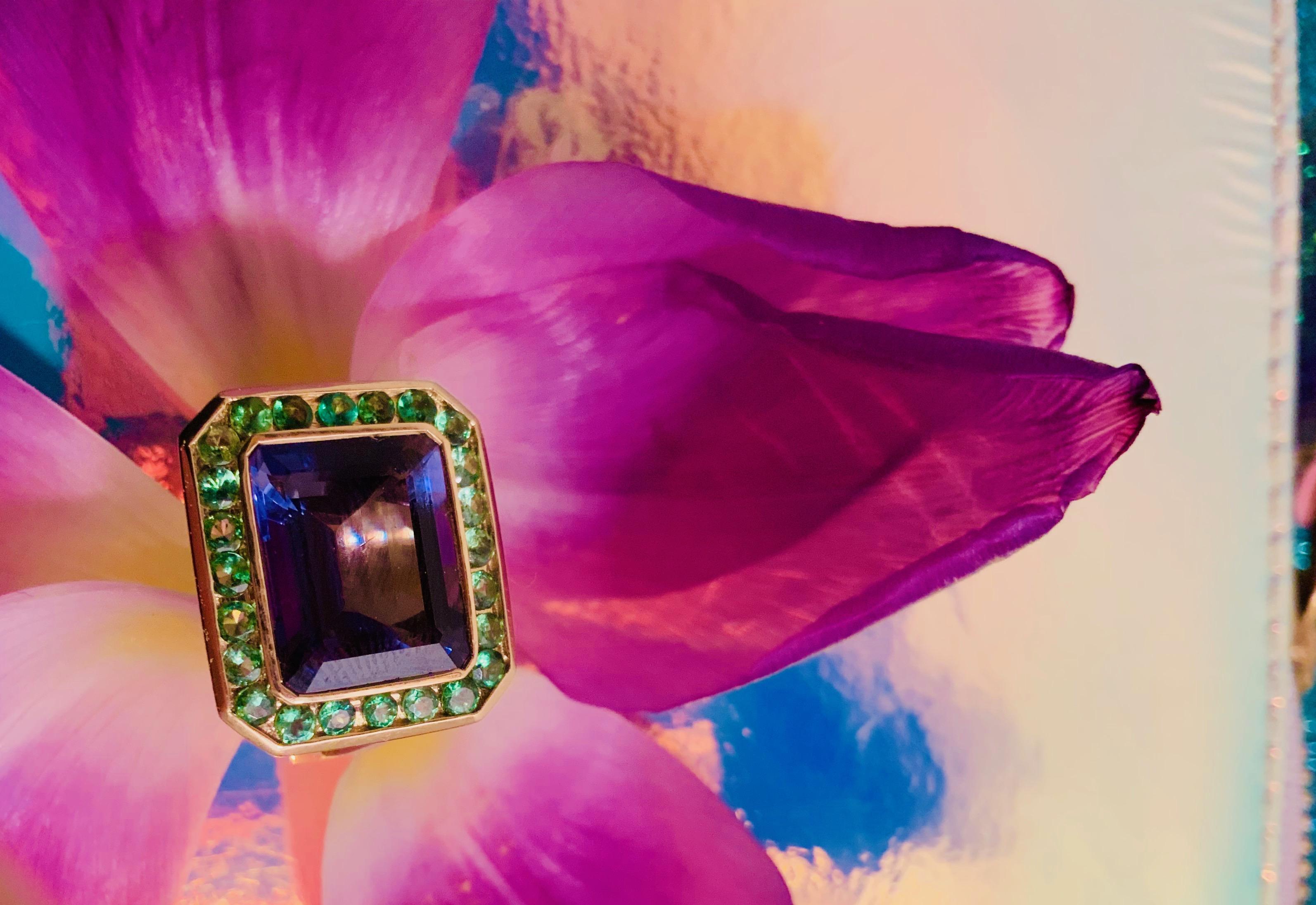 cette bague en or jaune 18 carats et à tige fendue, dont la pierre centrale est une iolite taillée en émeraude entourée d'un grenat vert, est une élégante bague de cocktail. Mesure 0,75 sur le dessus.

Cette bague peut être réalisée avec une pierre
