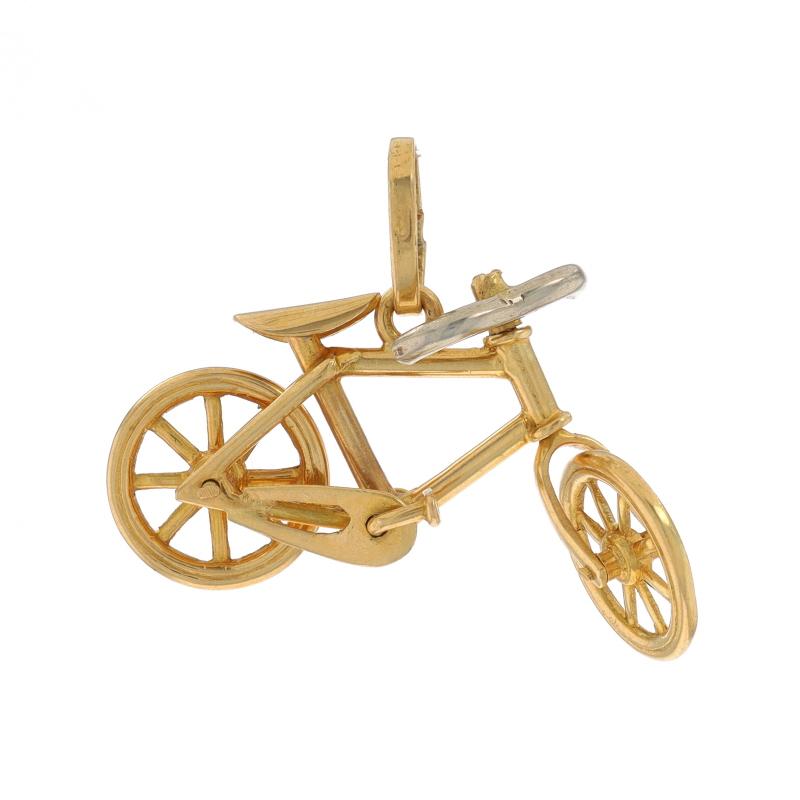 Contenu du métal : Or jaune 18k et or blanc 18k

Thème : Bicyclette, Cycliste, Sports
Caractéristiques : Les roues et les pédales tournent, la roue avant et le guidon se déplacent d'un côté à l'autre.

Mesures

Haut : 14 mm (9/16