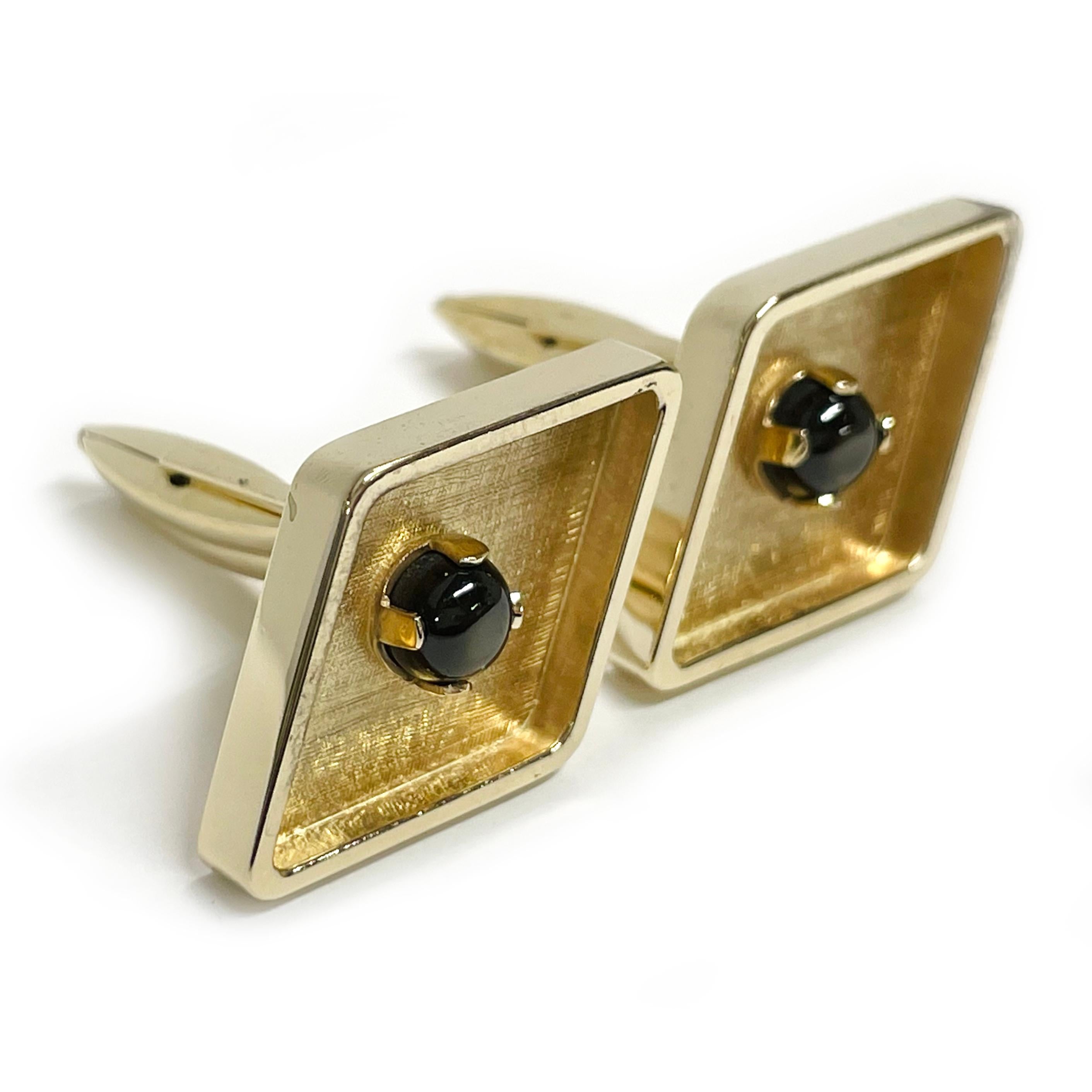 14 Karat Yellow Gold Black Star Sapphire Diamond-Shaped Gold Cufflinks. The cufflinks are diamond-shaped with rounded edges and a 5.6mm black star sapphire cabochon prong-set at in the center. The inside bezel front of the cufflinks has a Florentine