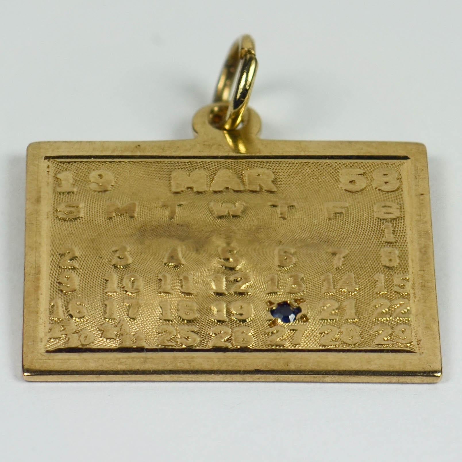 A 14 karat yellow gold charm pendant designed as the page from a calendar with the date 20th March 1958 picked out by a round blue sapphire. Stamped 14K for 14 karat gold and American manufacture.

Dimensions: 2.6 x 2.2 cm
Weight: 4.13 grams