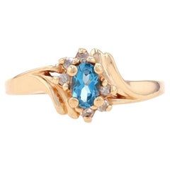 Bypass-Ring aus Gelbgold mit blauem Topas und Diamanten - 10k Oval .64ctw