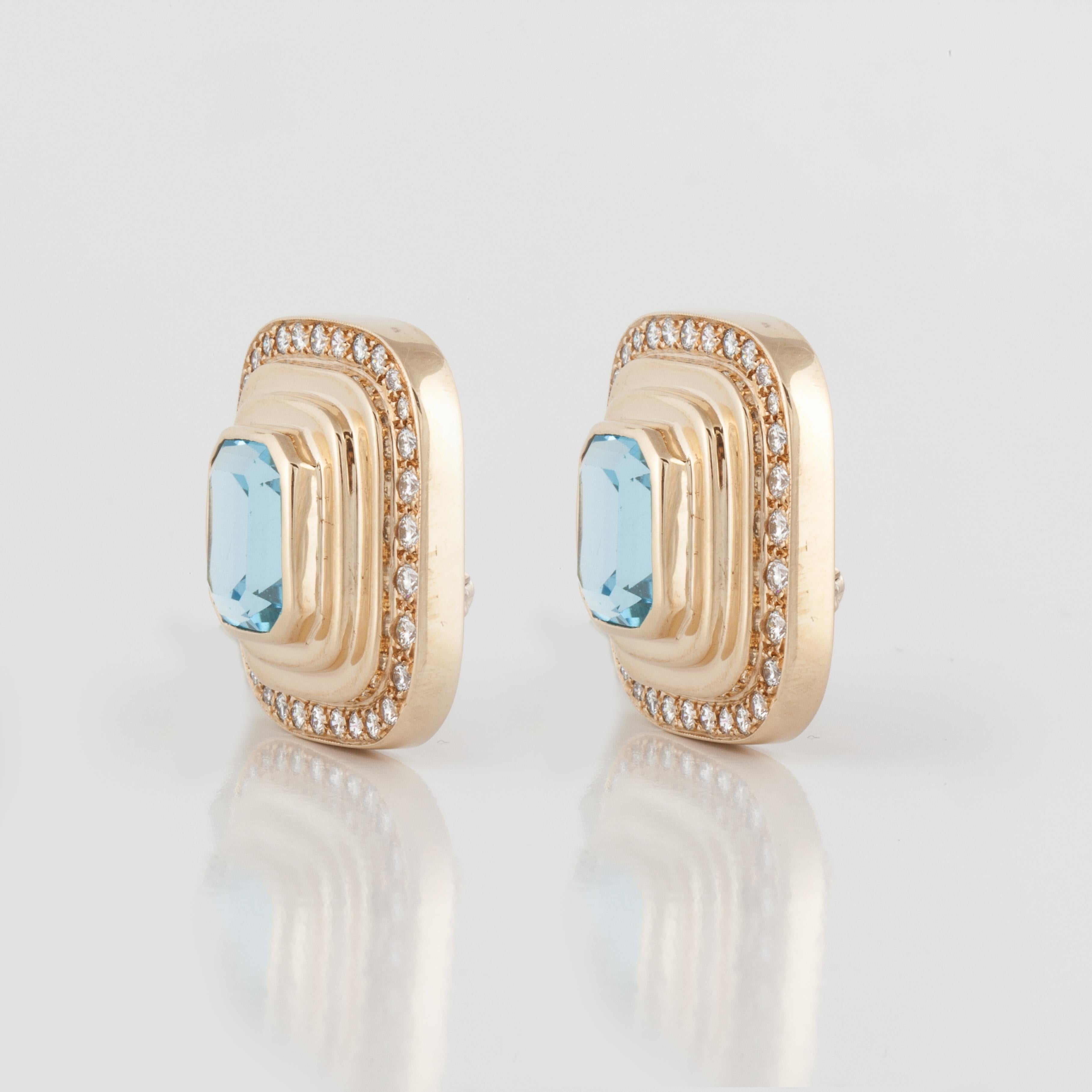 14K yellow gold earrings featuring blue topaz framed by round diamonds.  There are two (2) rectangular-cut blue topaz weighing 18 carats.  Framing the blue topaz are sixty-four (64) round diamonds totaling 2.60 carats; G-H color and VS clarity. 