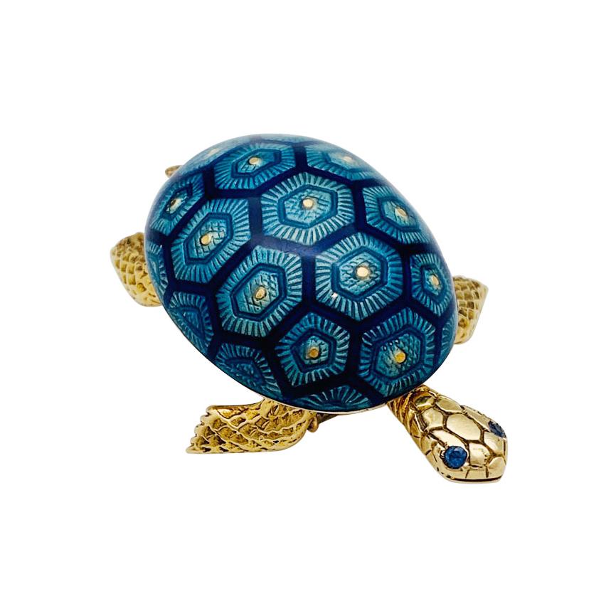 A 18Kt yellow gold Boucheron brooch in shape of a turtle, the turtle shell is enhanced with blue tones enamel and the eyes are set with sapphires. The head and legs are shaped like scales.
Circa 1960
Signed and Numbered, assay and maker's Hallmark