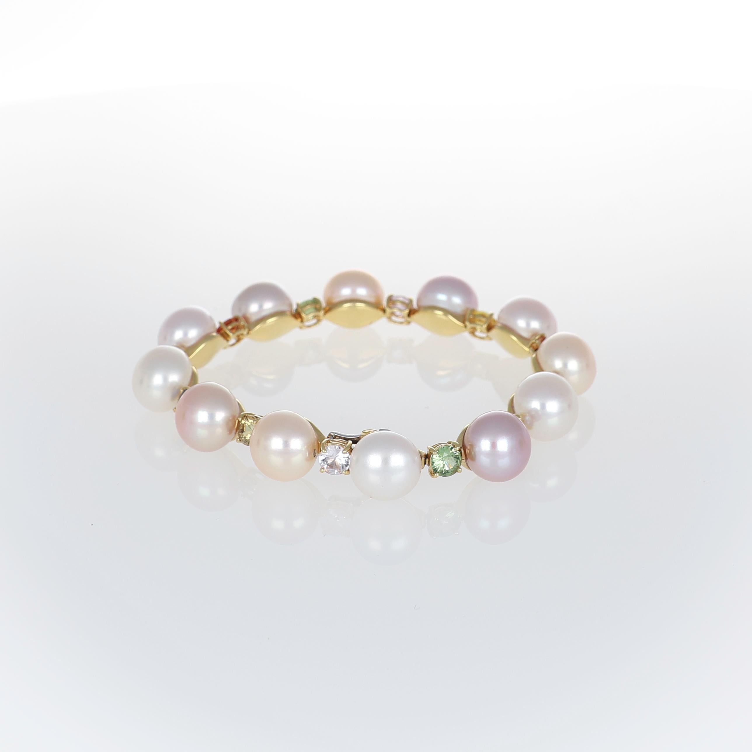 Un bracelet raffiné qui associe l'éclat doux des perles à la brillance des saphirs multicolores. Réalisée en or jaune, cette pièce présente une succession de perles lumineuses aux délicates teintes naturelles, entrecoupées de saphirs facettés
