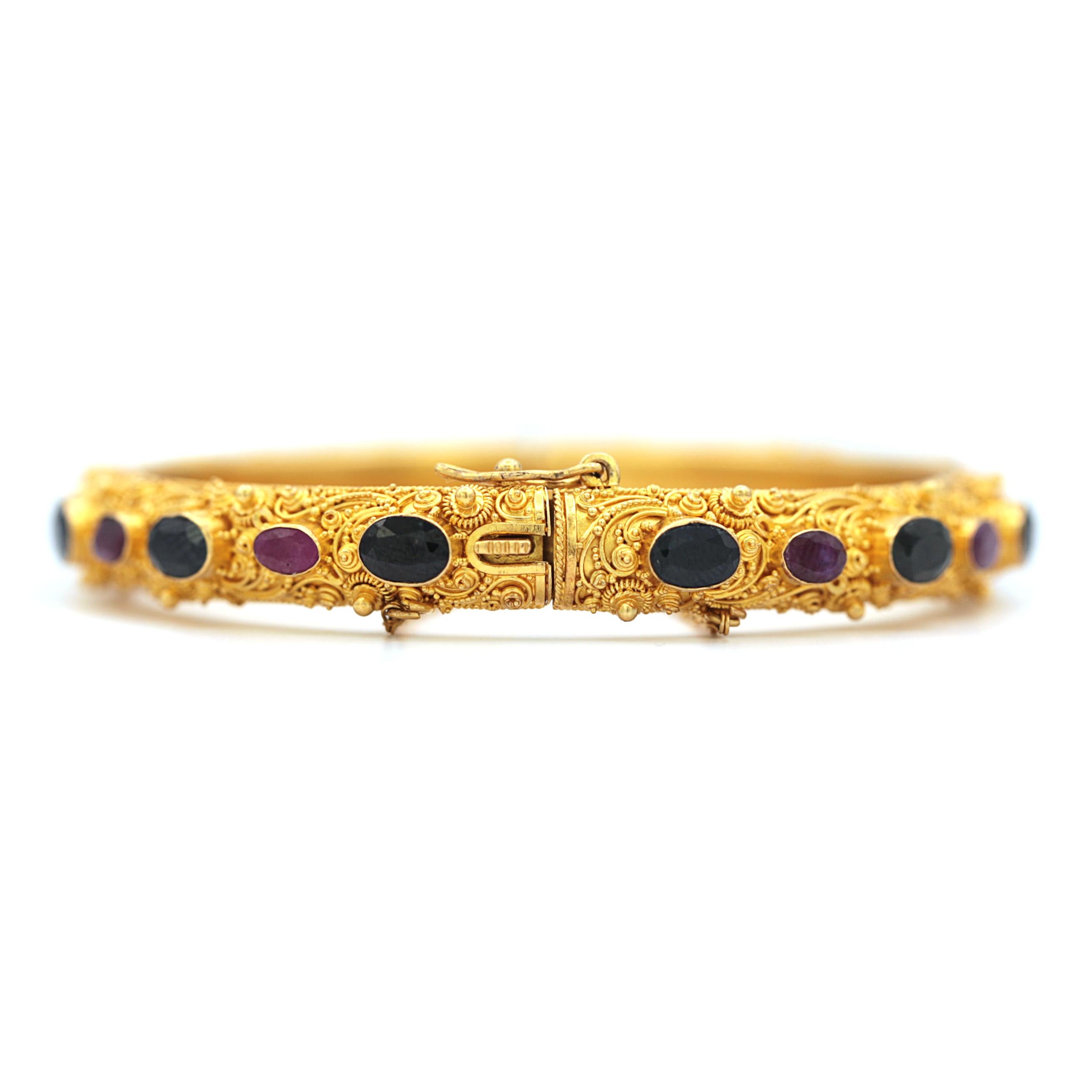 This 22 Karat Yellow Gold Bracelet is made out of 22 oval shape dark blue sapphires and red rubbies.
with a diameter of 5.5cm and 23.62 grams.

Every Upper-Luxury piece will arrive in an elegant jewelry box.
