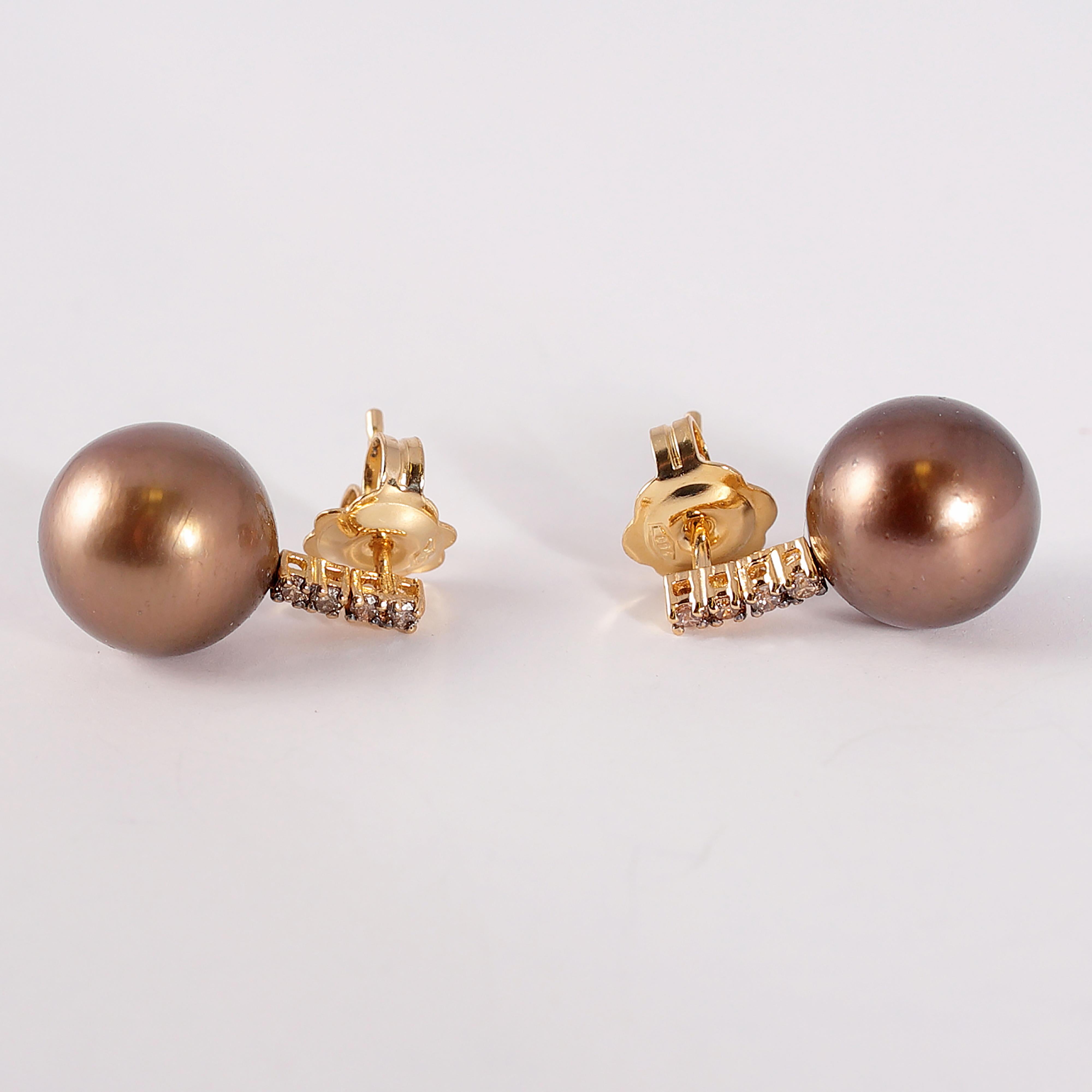 These pearls run the gamut of brown colors!  The 18 karat yellow gold mountings are the perfect backdrop for the 10.00 mm Tahitian pearls and the 0.15 carats of brown diamonds.  They are secured with a standard friction back. 
