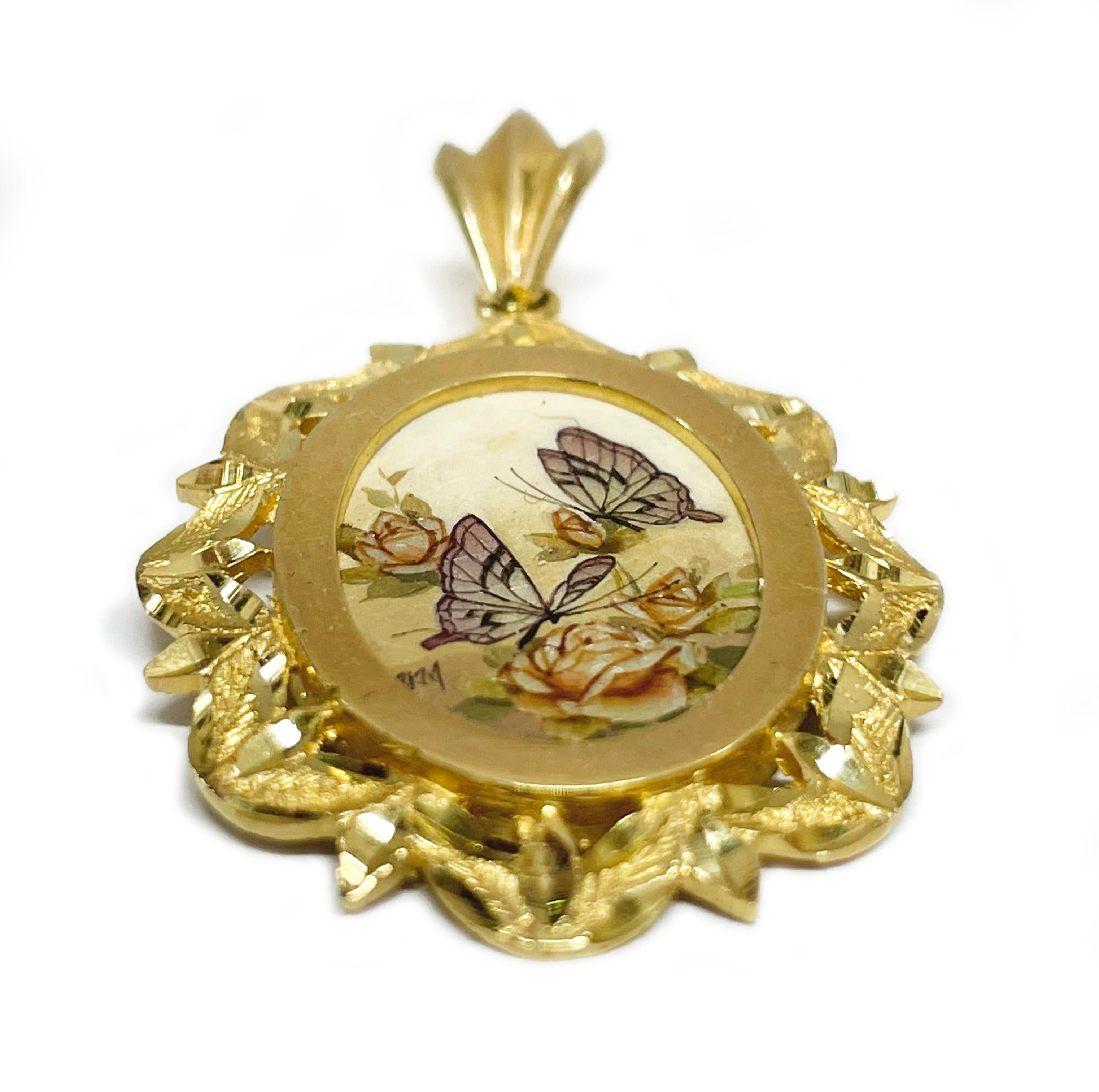 14 Karat Yellow Gold Butterflies and Roses Hand Painted on a Mother of Pearl Pendant. The miniature painting is set in a 14 karat gold ornate oval frame with diamond-cut details. The painting is signed by the master artist, BKM Brian M. The pendant